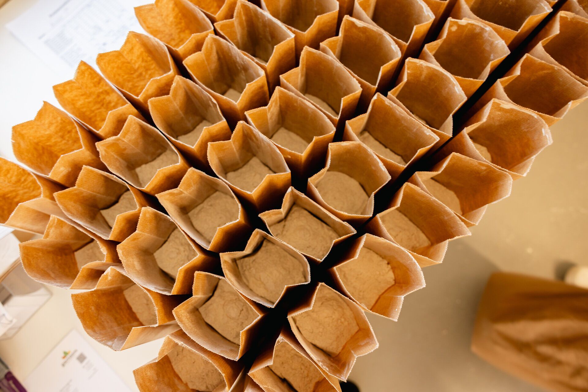 Mehrere braune Papiersäckchen mit hellem Inhalt.