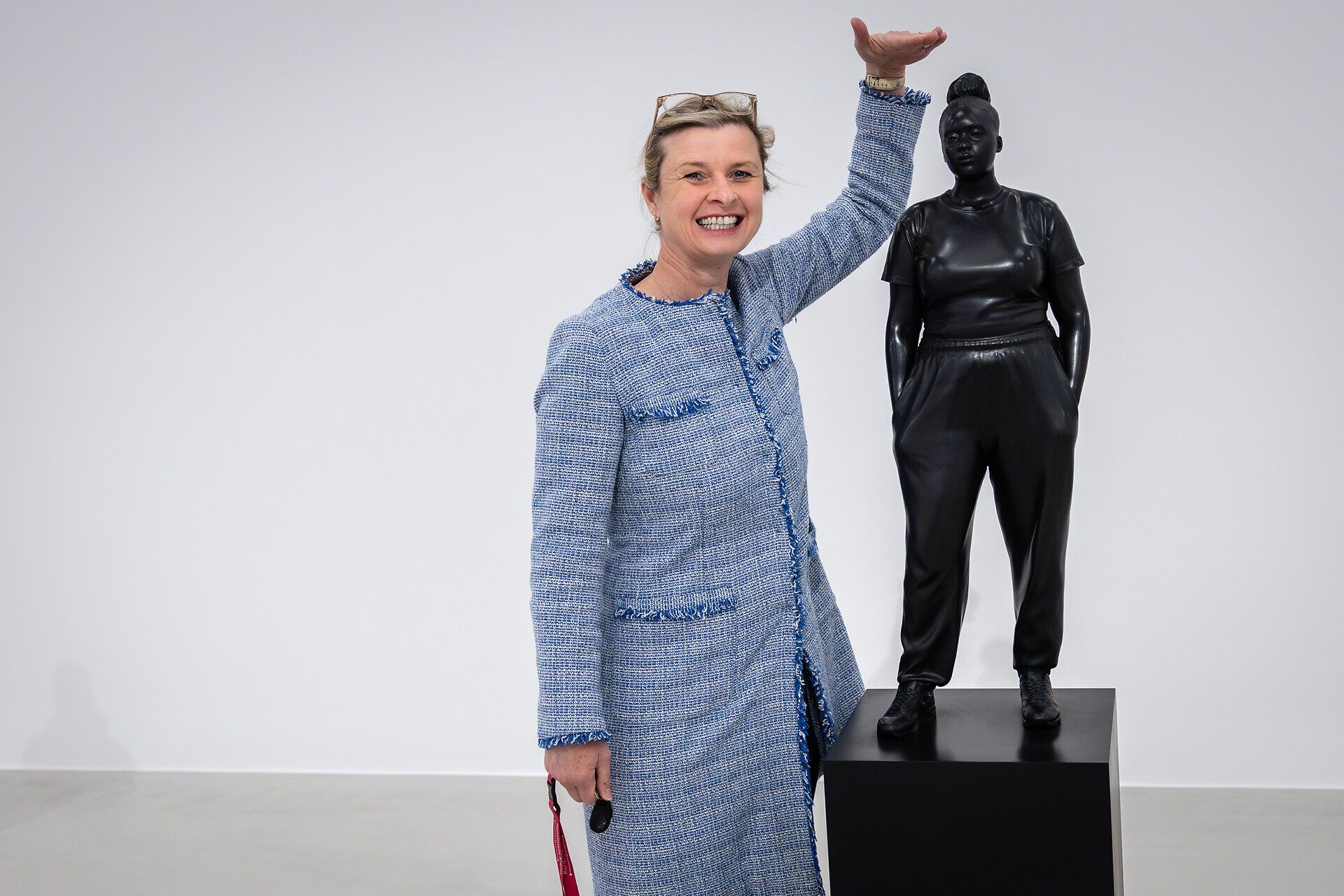 Julia Flunger-Schulz steht neben einer schwarzen Skulptur.