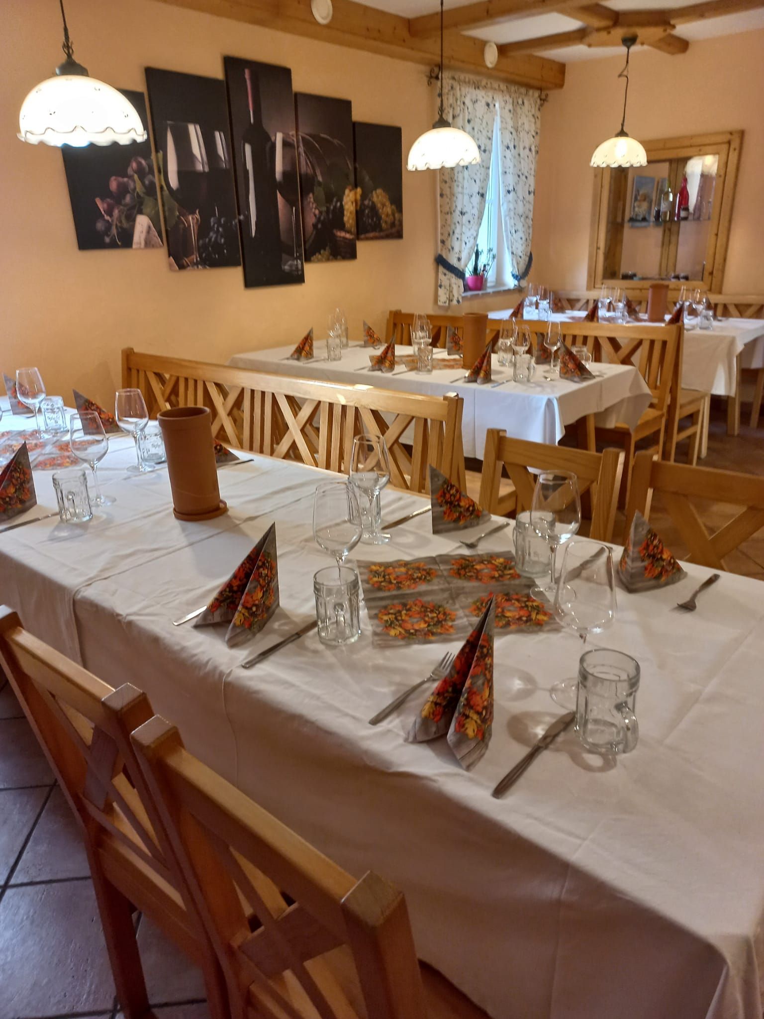 gedeckte Tische innnen mit weißer Tischdecke und Servietten 