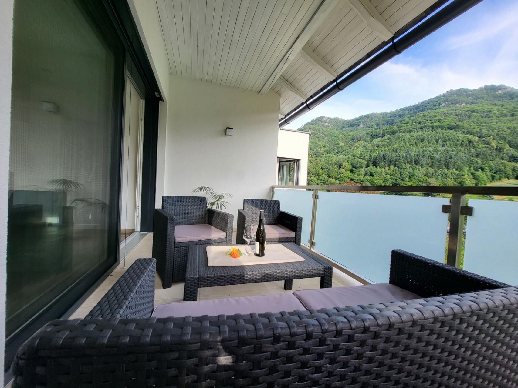 Balkon mit Rattanmöbeln und Bergblick.
