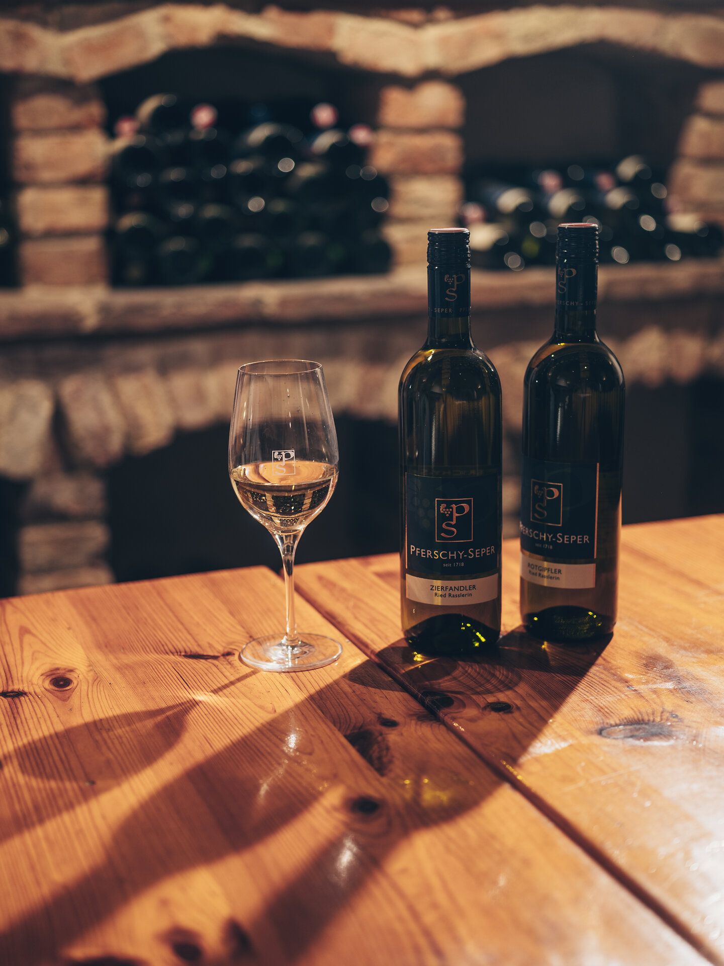 Gelbes Gebäude mit rotem Dach vor Weinbergen in Spitz an der Donau.