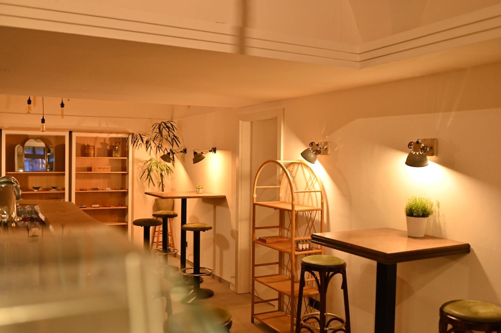 Innenansicht eines gemütlichen Cafés mit Holzmöbeln und warmem Licht.