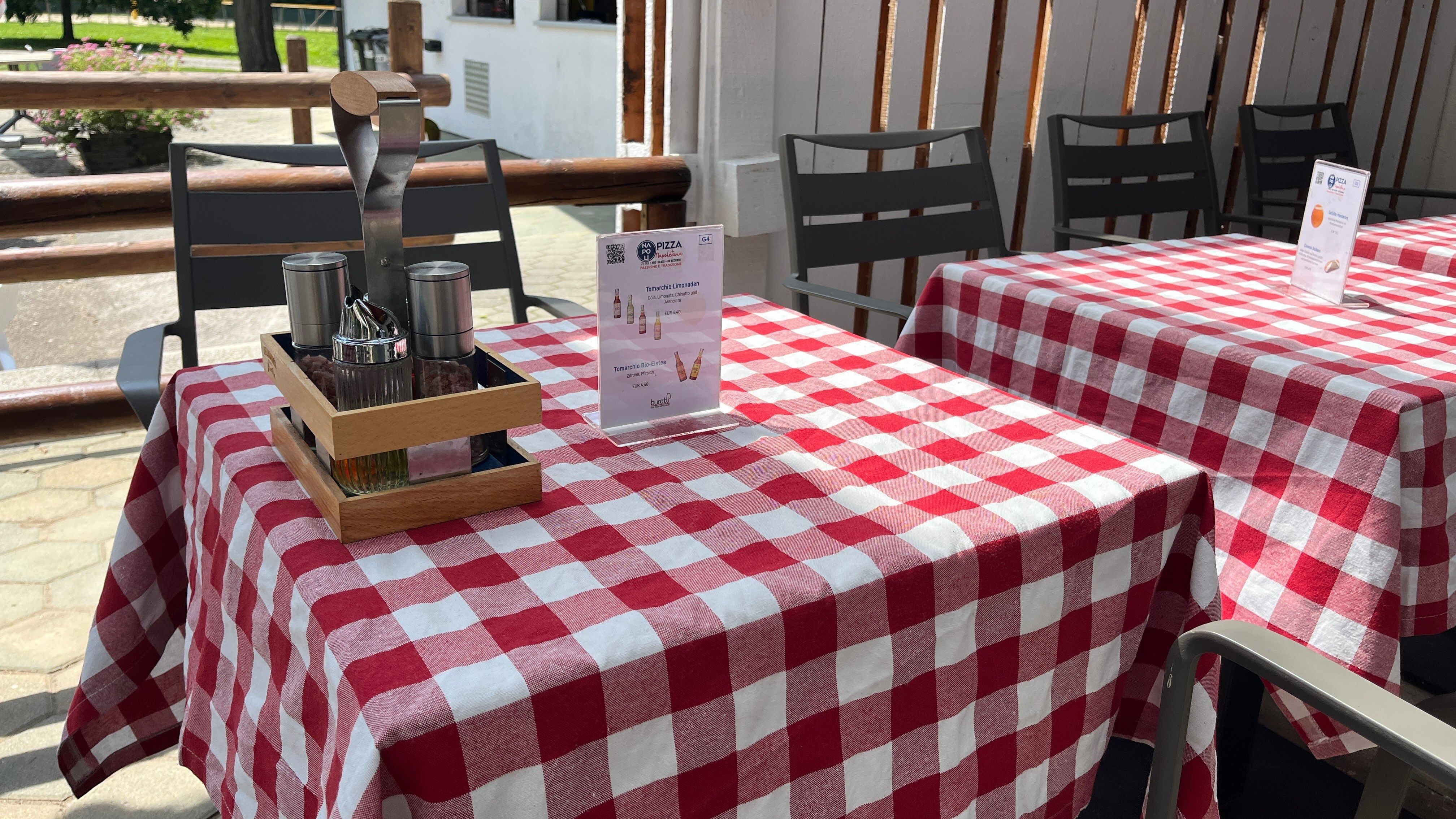 Gedeckter Tisch mit roter Tischdecke und Speiseempfehlung.