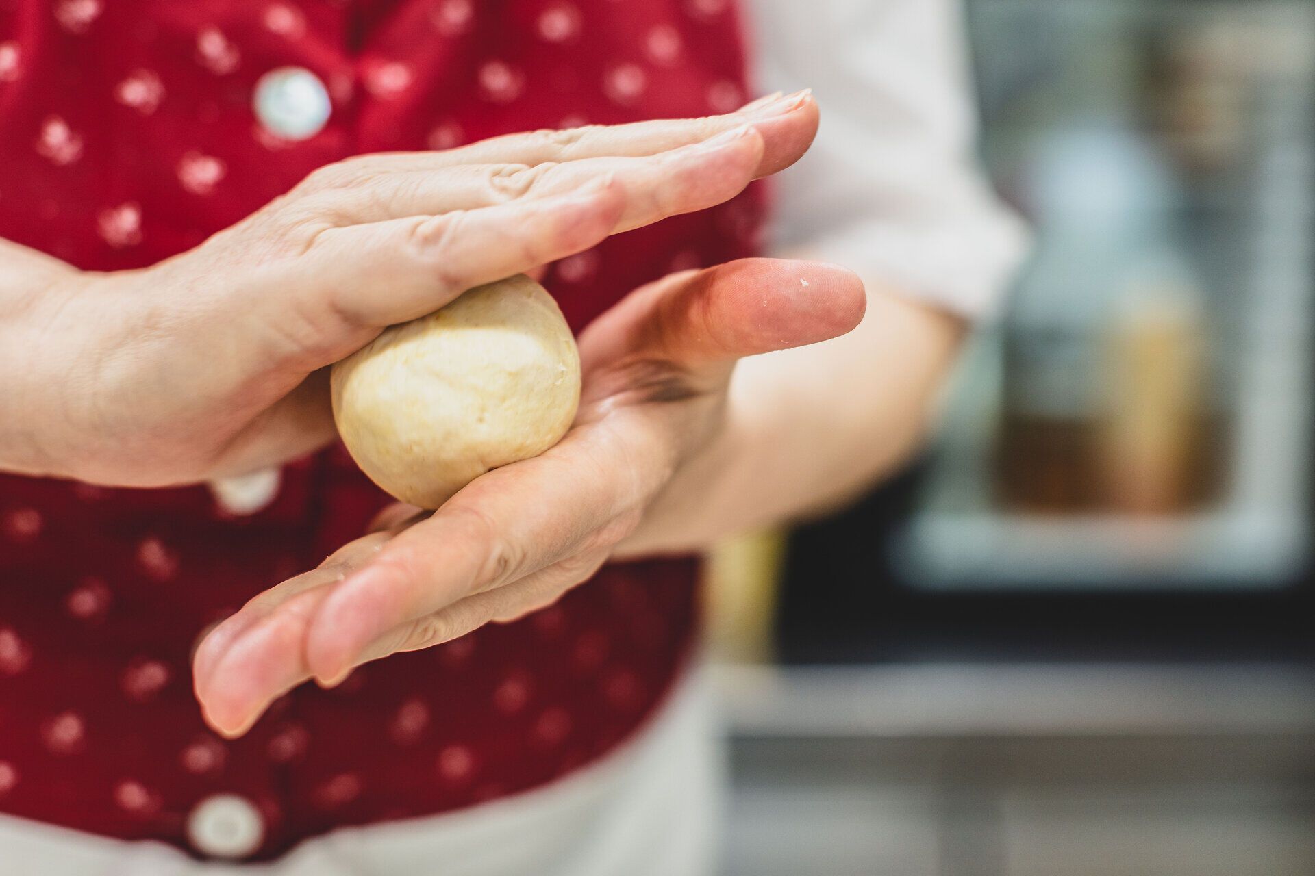 Die Hände formen liebevoll einen Marillenknödel, ein köstliches Symbol des Sommers. Die frischen, saftigen Marillen versprechen ein Geschmackserlebnis, das die Sinne verzaubert. Ein Hauch von Tradition und Genuss liegt in der Luft, während die Vorfreude auf die Wachauer Spezialität wächst.