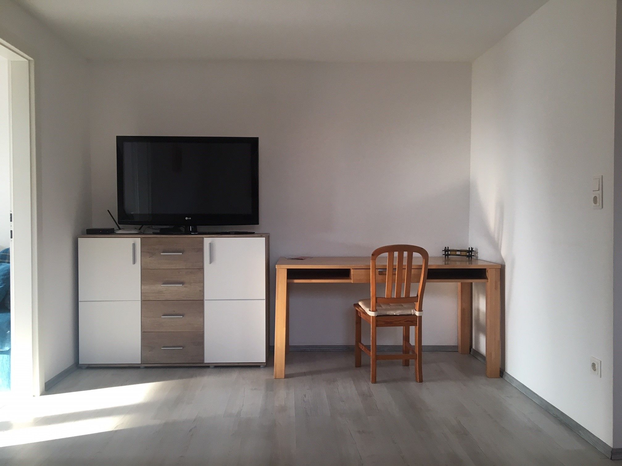 Wohnzimmer mit TV und Schreibtisch 