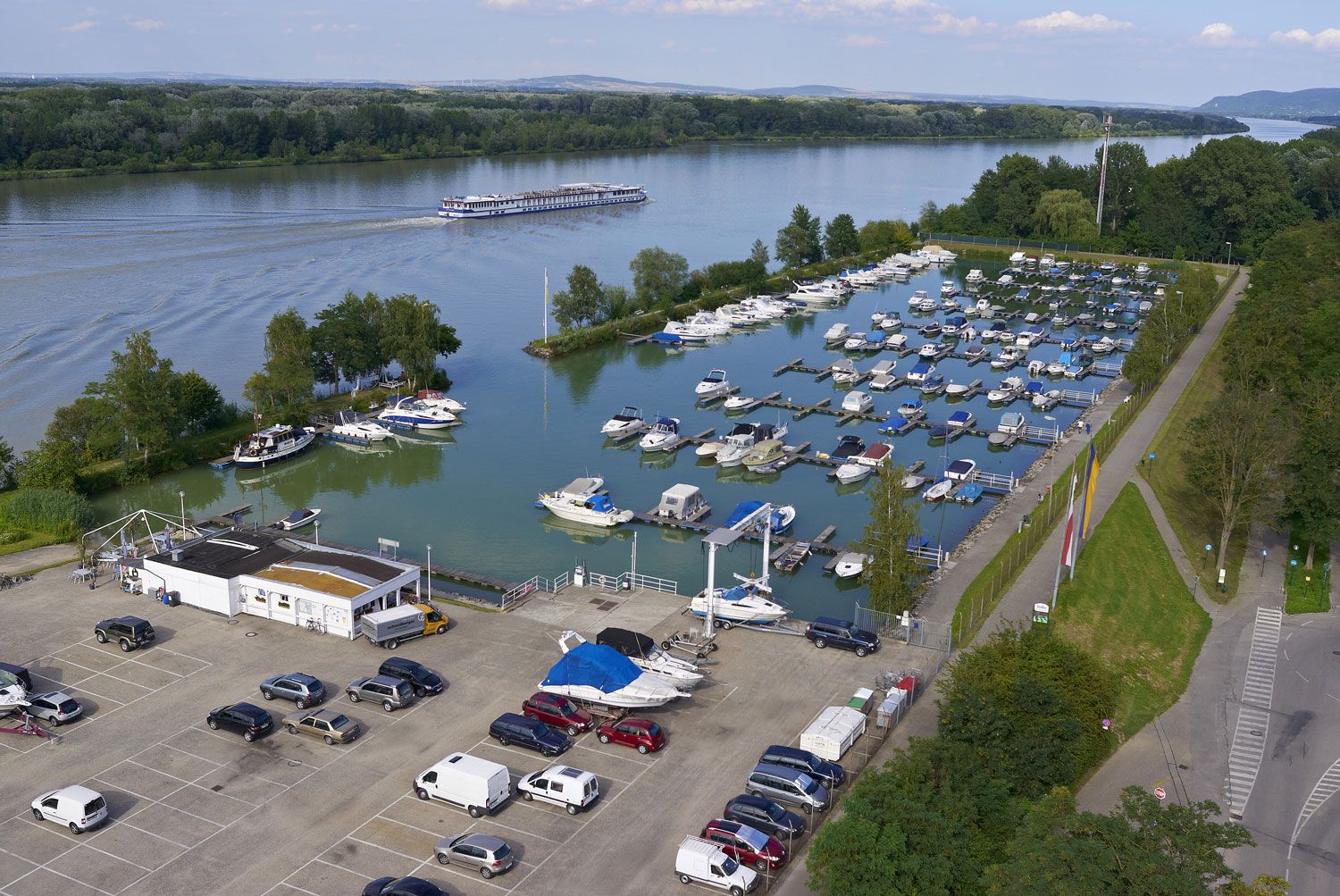 Aerial view of the Tulln marina with many boats and a river in the background.