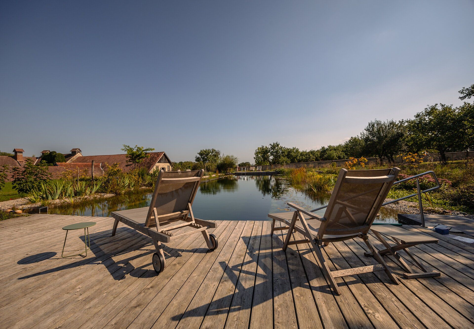 Entspannen Sie in dieser idyllischen Oase, wo die sanften Wellen des Wassers und die üppige Vegetation eine harmonische Atmosphäre schaffen. Die bequemen Liegen laden dazu ein, die Seele baumeln zu lassen und die Schönheit der Natur zu genießen.