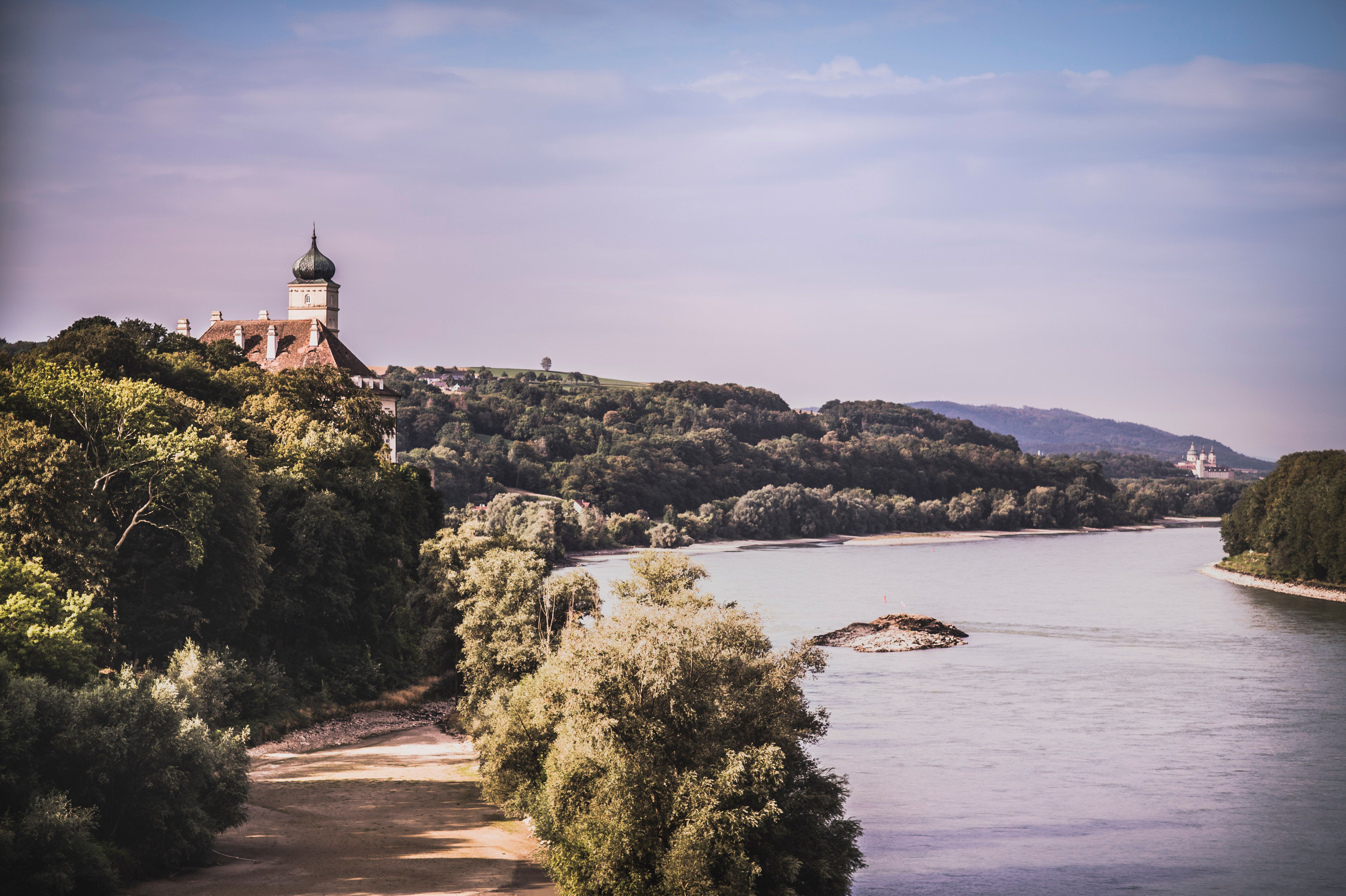 Blick auf Schloss Schönbühel und die Donau mit bewaldeten Ufern.