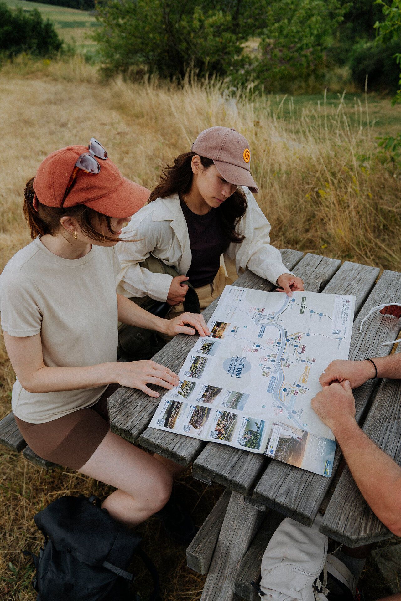 2 Wanderinnen betrachten die Schatzkarte Nibelungengau bei einem Rastplatz am Weitwanderweg Nibelungengau