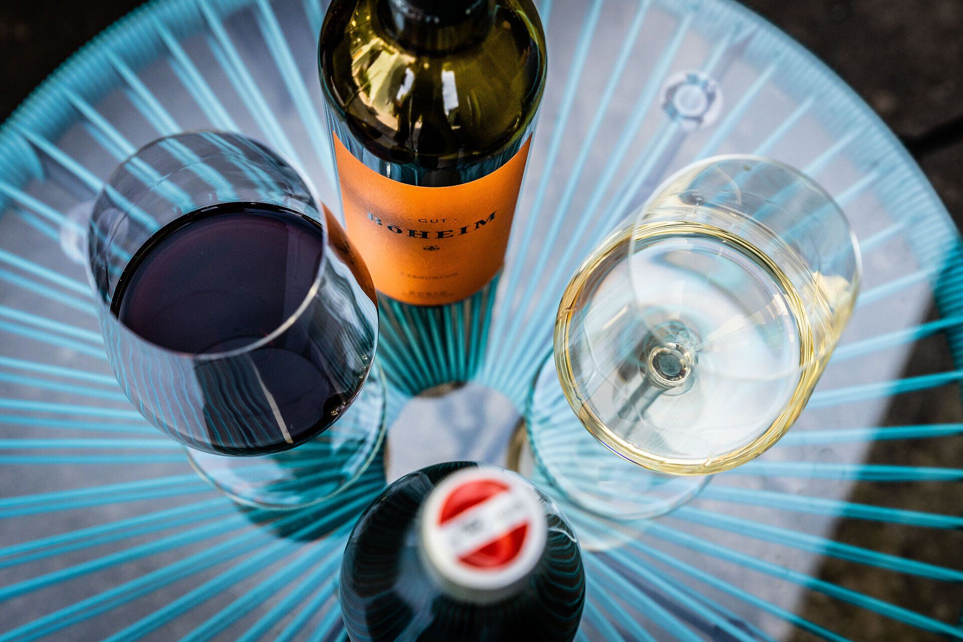 Zwei Weingläser und zwei Weinflaschen auf einem Tisch. 