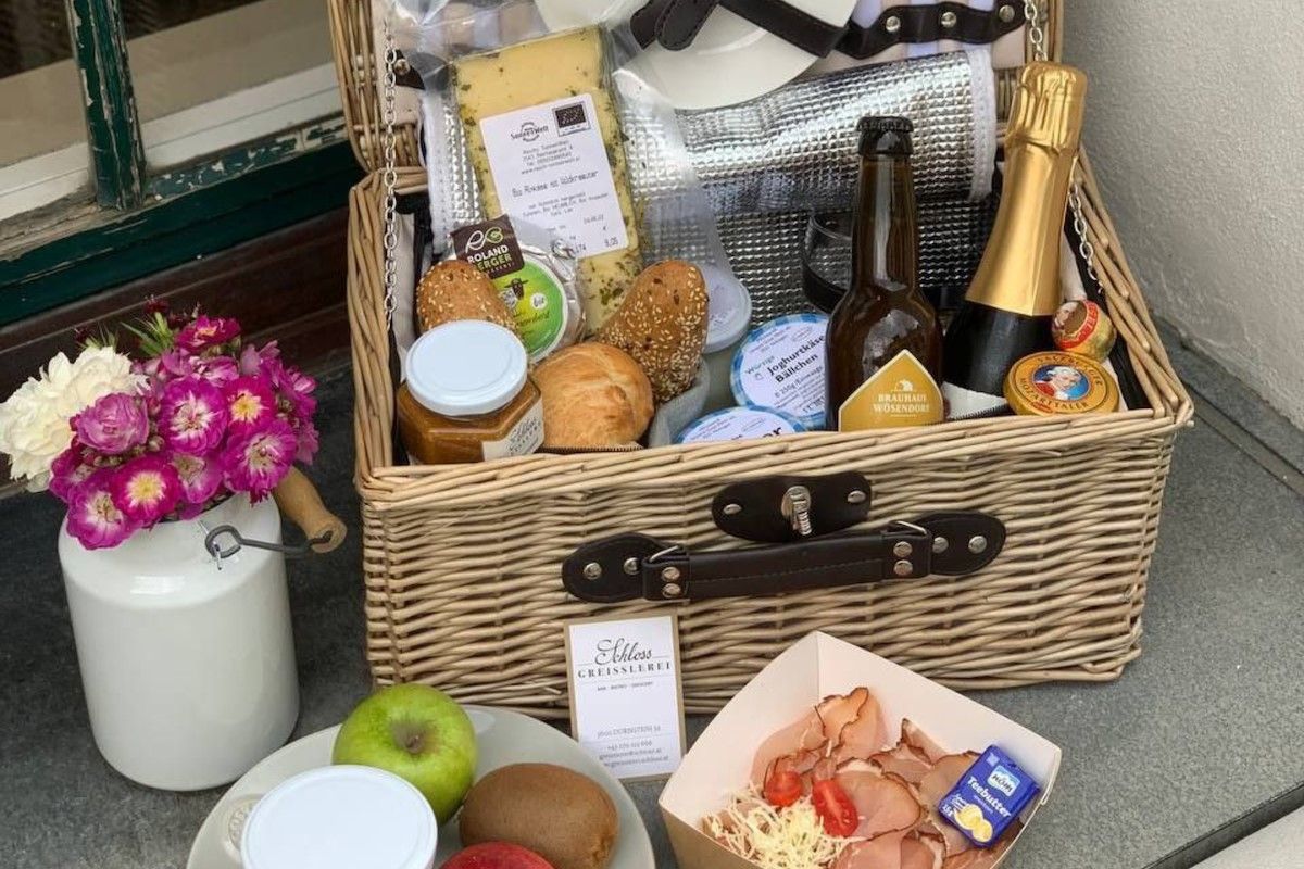 Ein prall gefüllter Picknickkorb mit Speisen und einer Flasche Wein