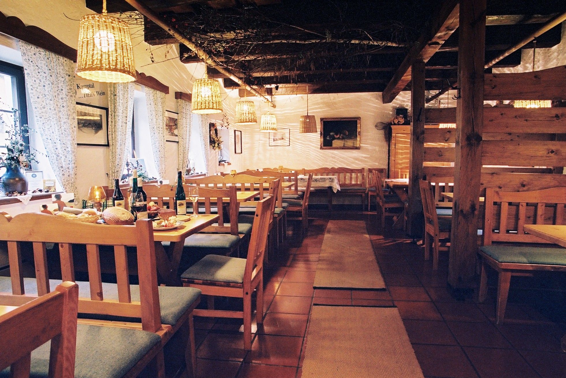 Gemütlicher Innenraum eines traditionellen Heurigen mit Holzmöbeln und gedeckten Tischen.