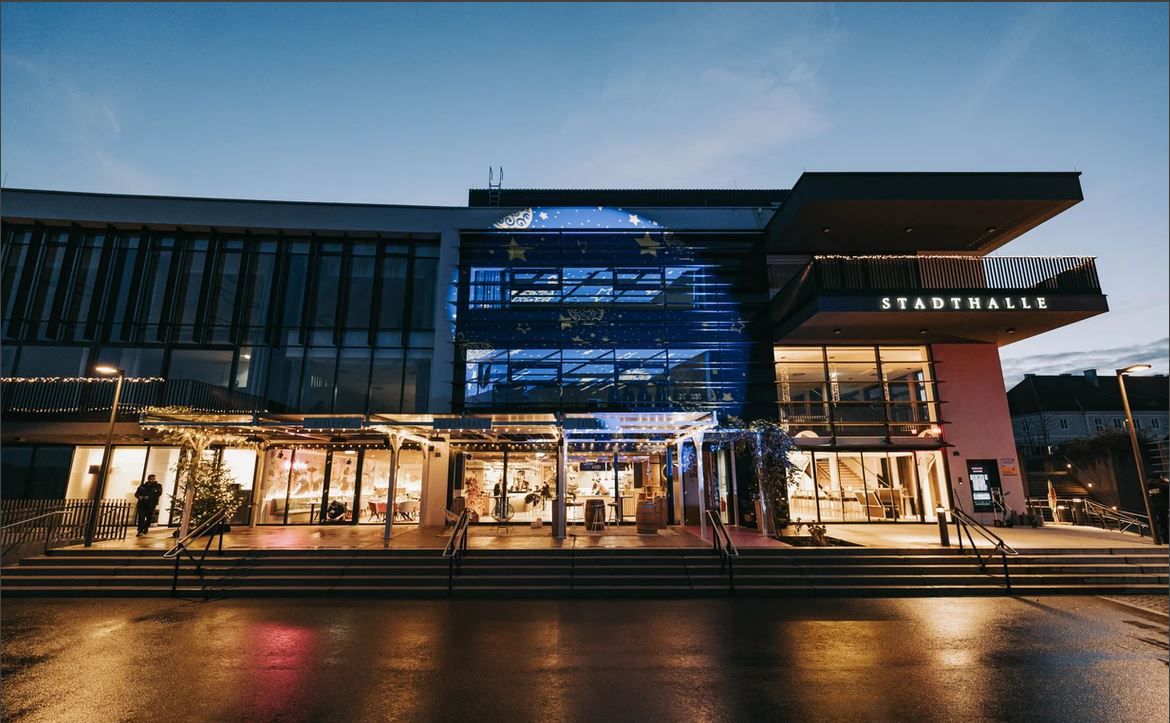 Außenansicht der Stadthalle Ybbs bei Dämmerung mit beleuchtetem Eingang.