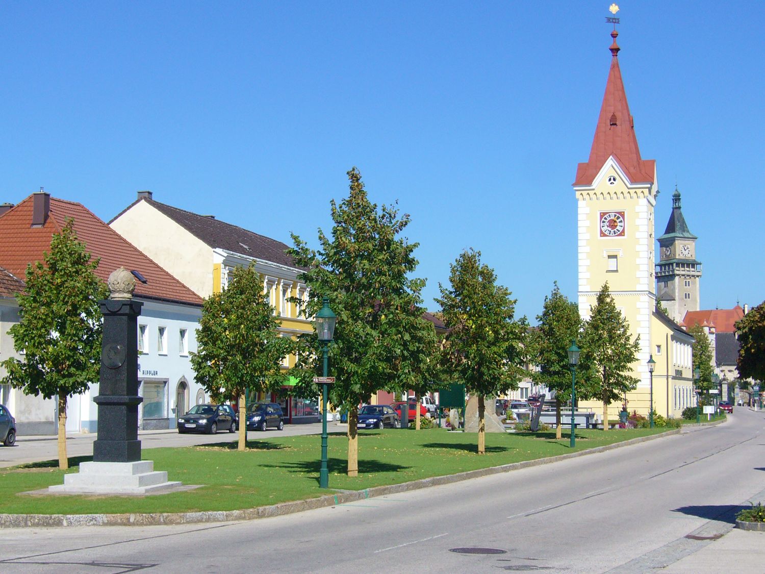 Stadtzentrum mit Turm und Schloss im Hintergrund.