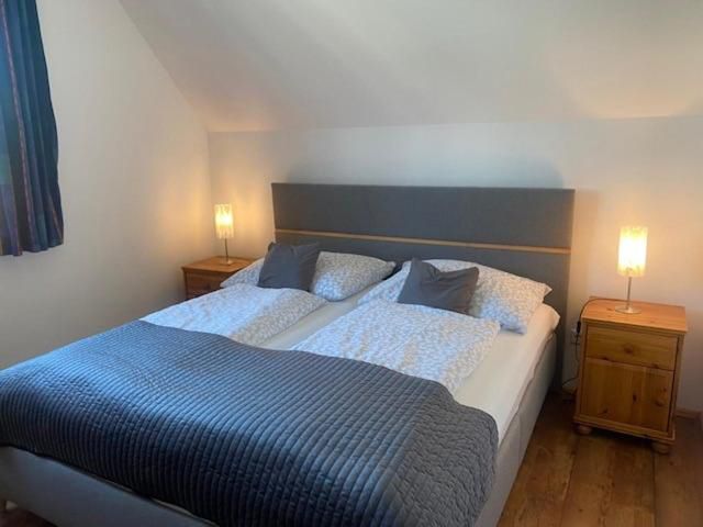 Gemütliches Schlafzimmer mit Doppelbett, zwei Nachttischen und Lampen.