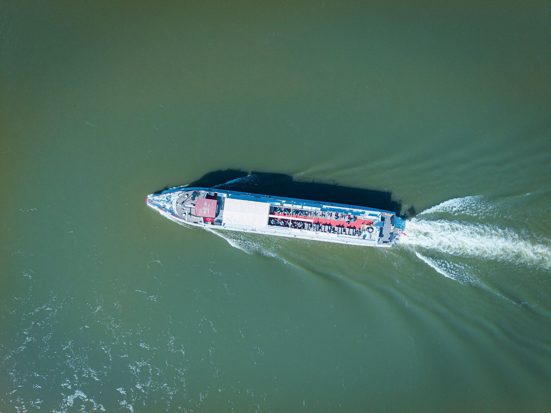 Ein majestätisches Schiff gleitet sanft über die glitzernde Donau, während die sanften Wellen die Ufer umspielen. Die umliegende Landschaft, geprägt von üppigem Grün und malerischen Hügeln, lädt zu einem unvergesslichen Abenteuer ein. Hier, wo Natur und Kultur harmonisch verschmelzen, wird jeder Moment zum Erlebnis.