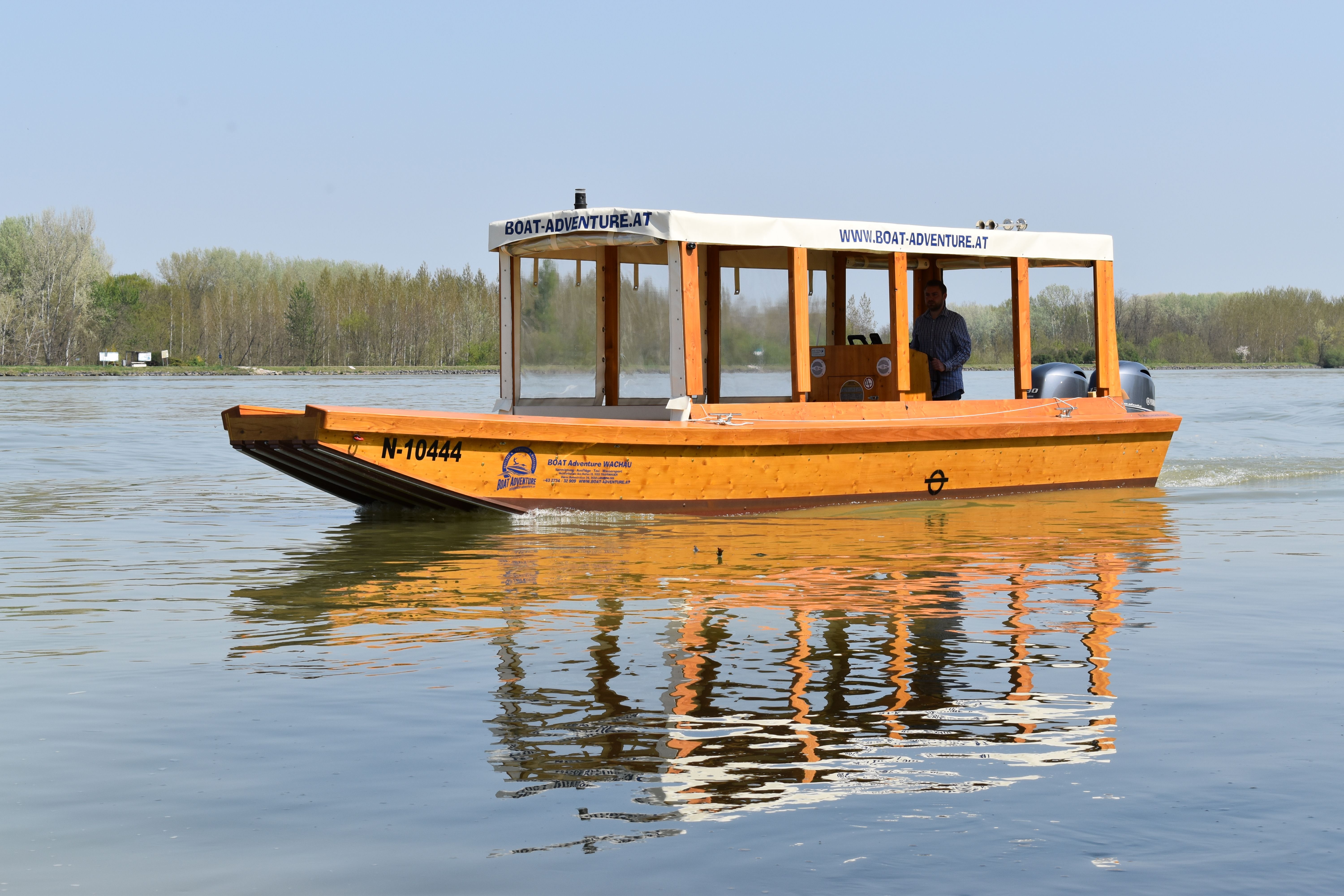 Holz-Zille auf dem Wasser mit Gras im Hintergrund
