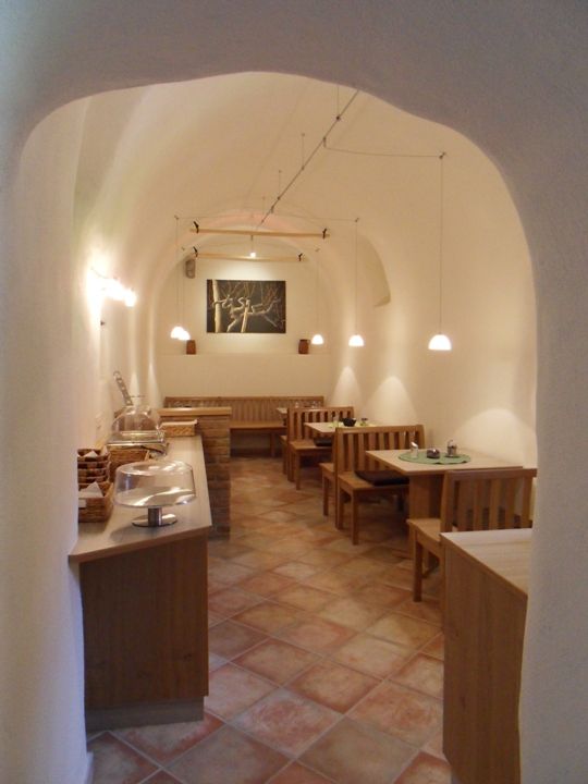 Ein gemütlicher Frühstücksraum mit Holzmöbeln und gewölbter Decke.