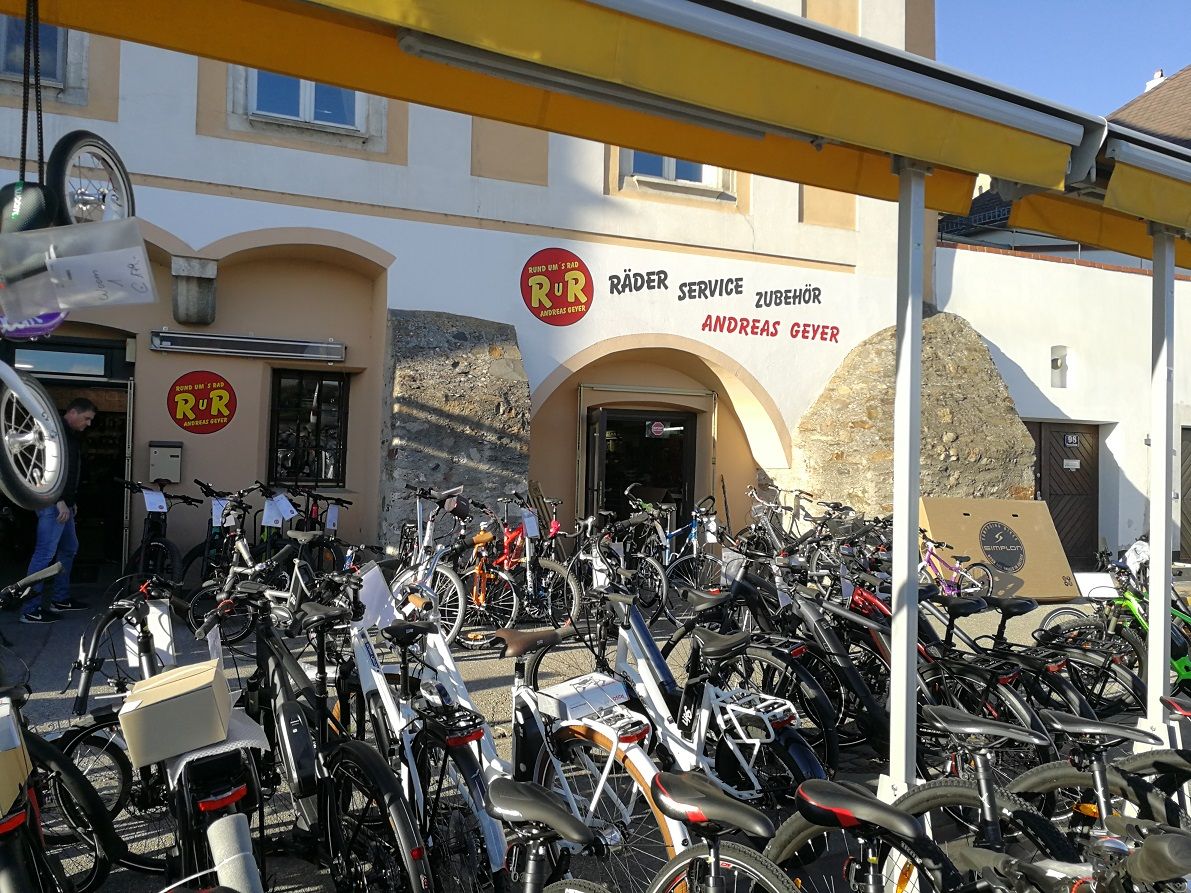 Bicycle store with many bicycles in front of the entrance.