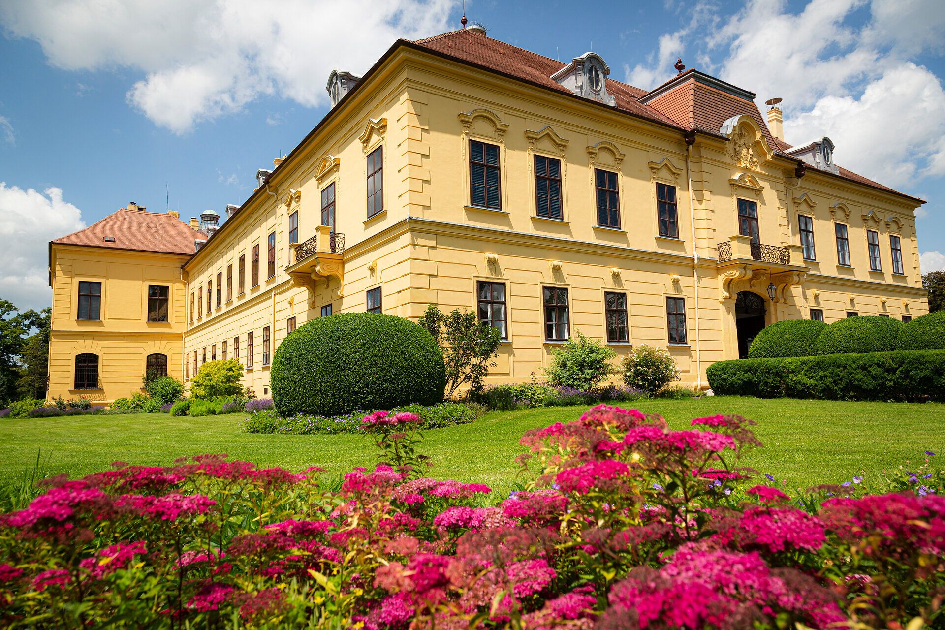 Umgeben von üppigen Gärten und blühenden Pflanzen strahlt das Schloss eine majestätische Ruhe aus. Die harmonische Verbindung von Architektur und Natur lädt dazu ein, die Seele baumeln zu lassen und die Schönheit der Umgebung zu genießen.