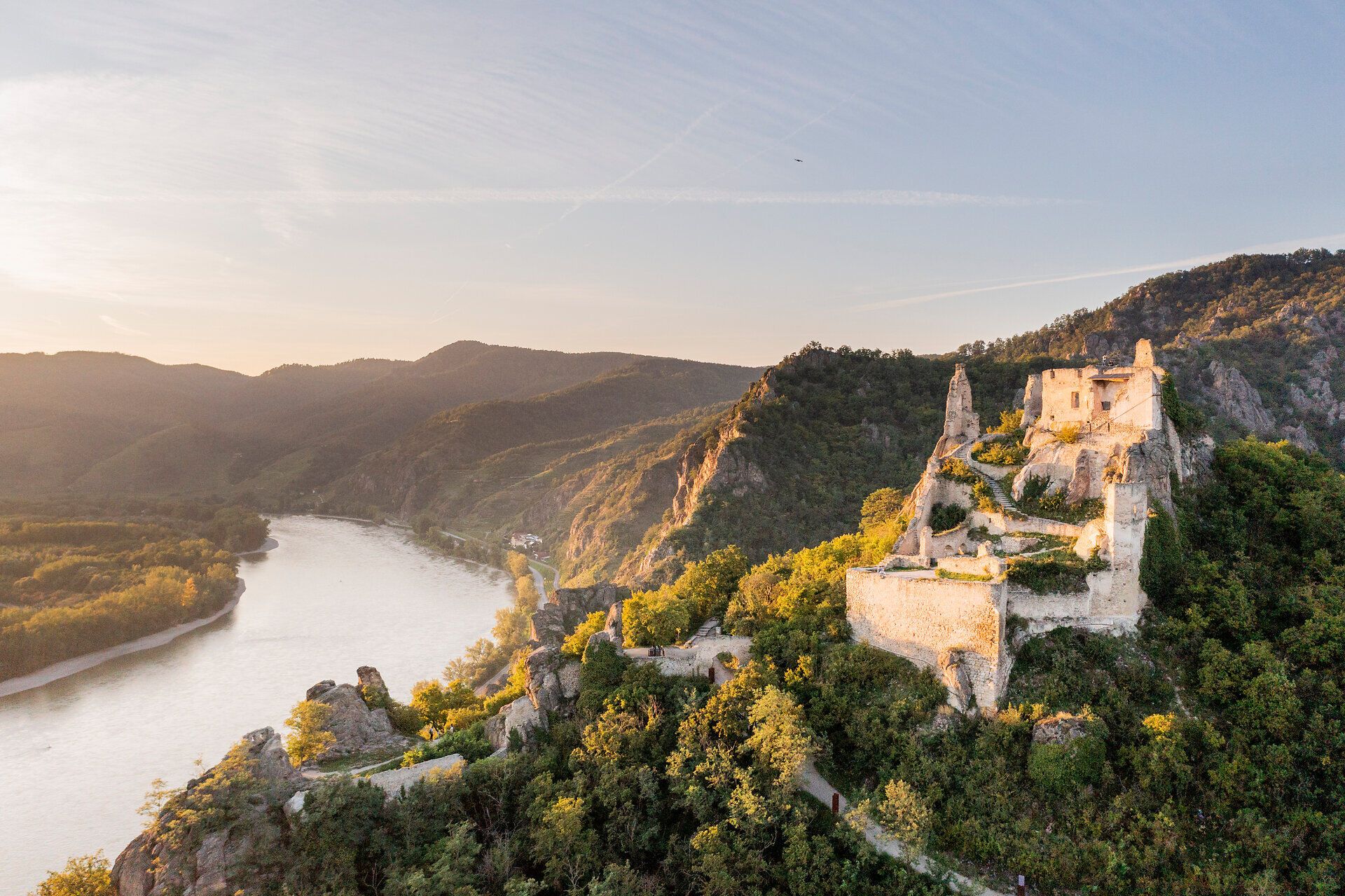 Die Ruine thront majestätisch über der Donau und bietet einen atemberaubenden Blick auf die umliegenden Weinberge. Die sanften Hügel und das glitzernde Wasser schaffen eine malerische Kulisse, die zum Verweilen einlädt. Hier spürt man die Geschichte und die Schönheit der Natur in jedem Moment.