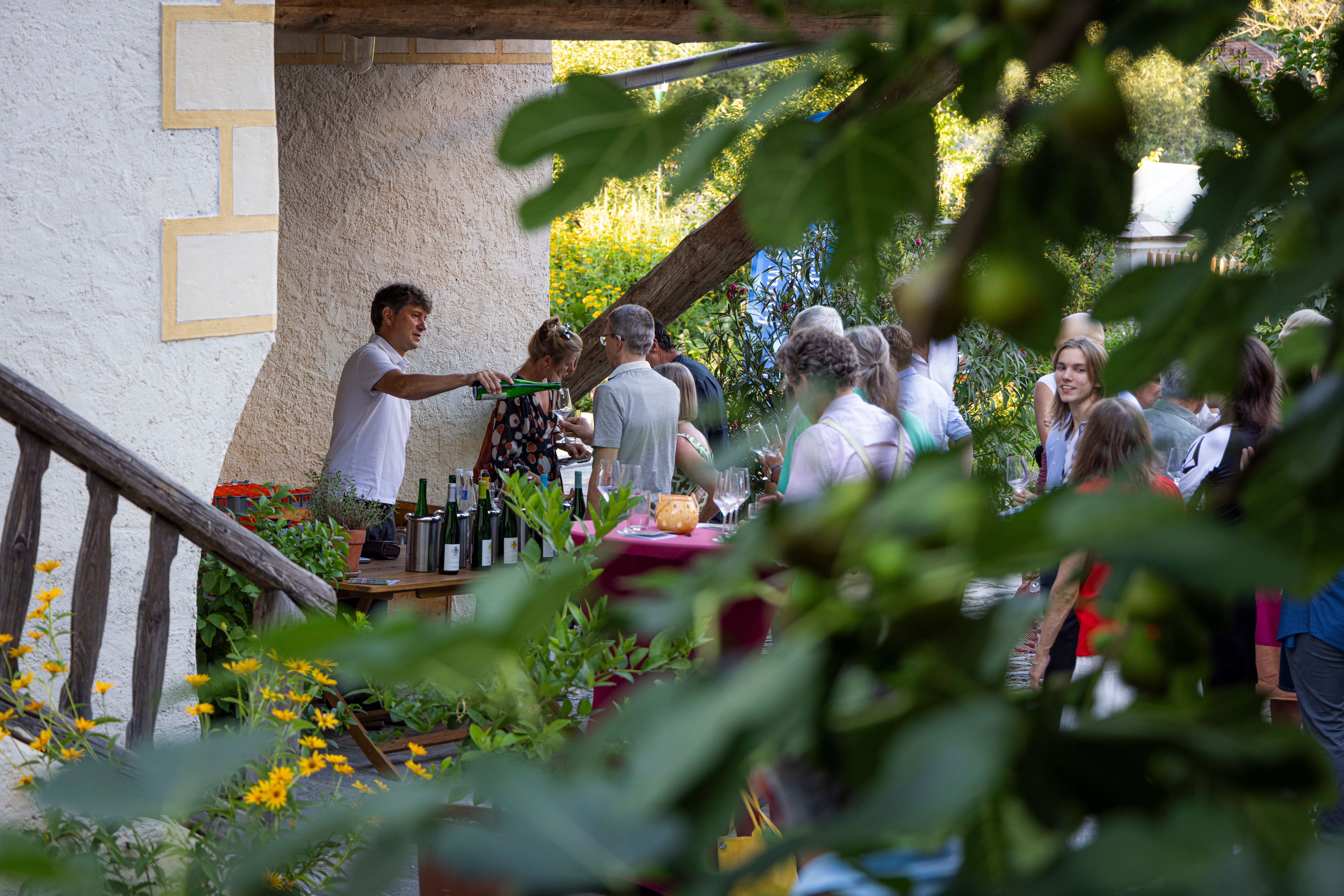 Menschen unterhalten sich und trinken Wein in der Adam Mühle in Spitz