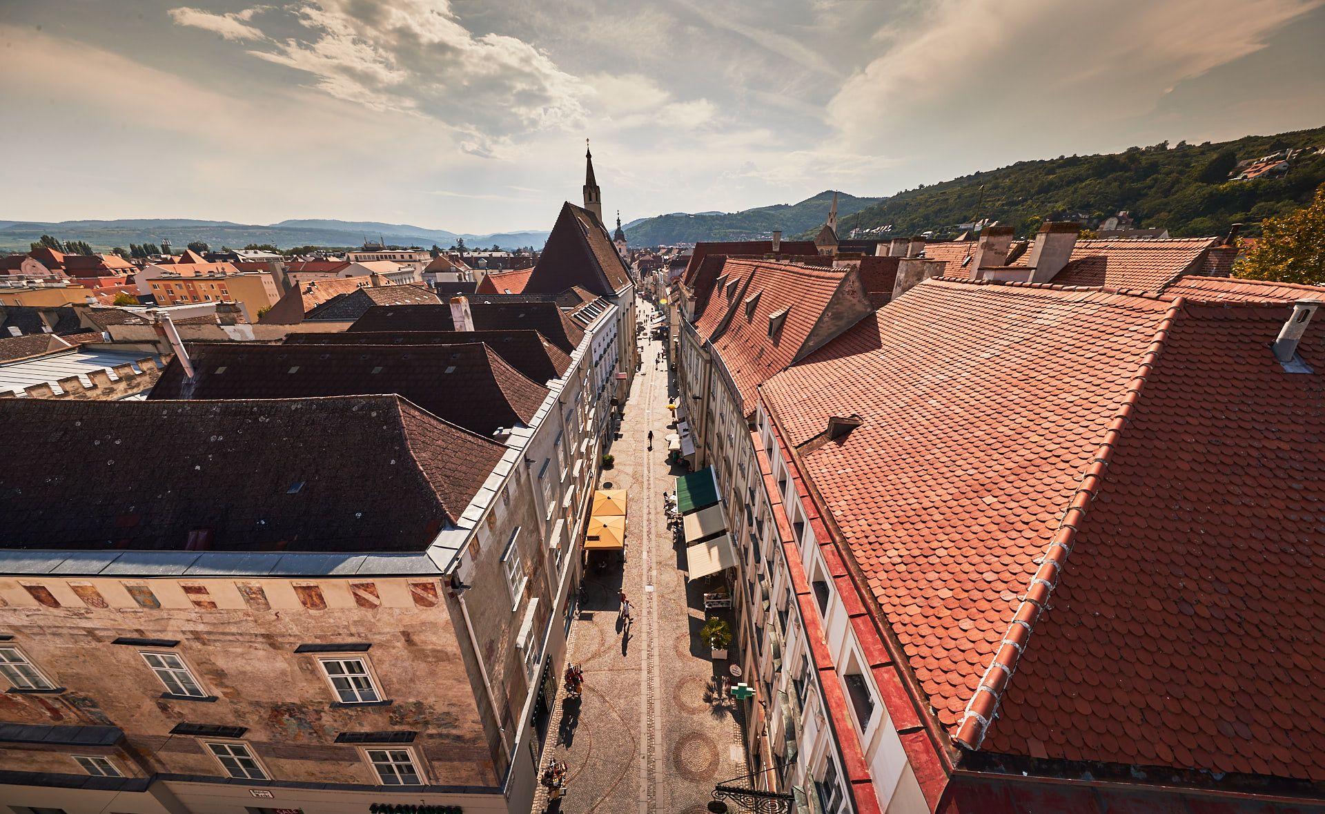 Luftaufnahme der Altstadt von Krems mit roten Ziegeldächern und einer zentralen Straße.