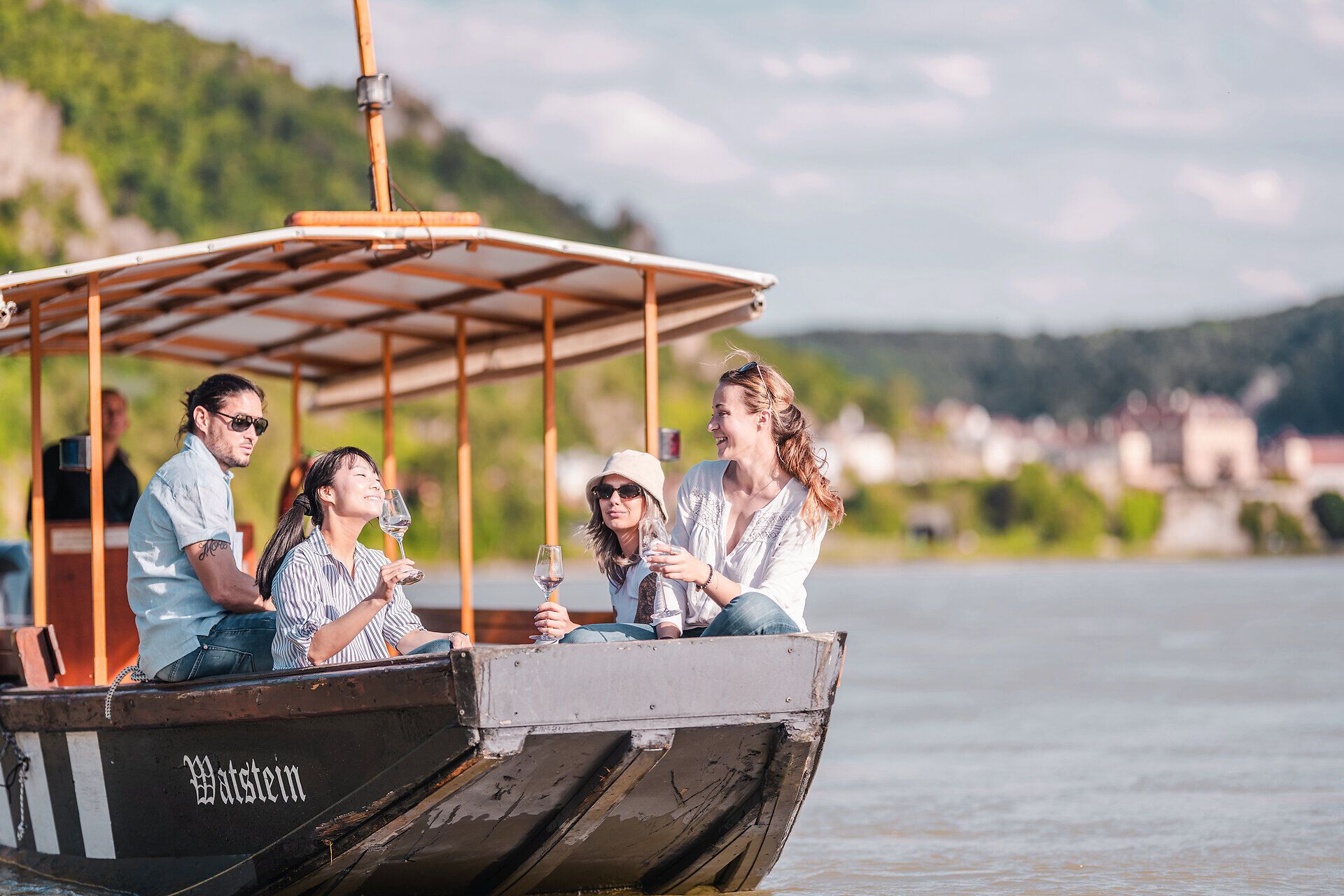 Eine Holzzille mit Menschen fährt auf der Donau in der Wachau.