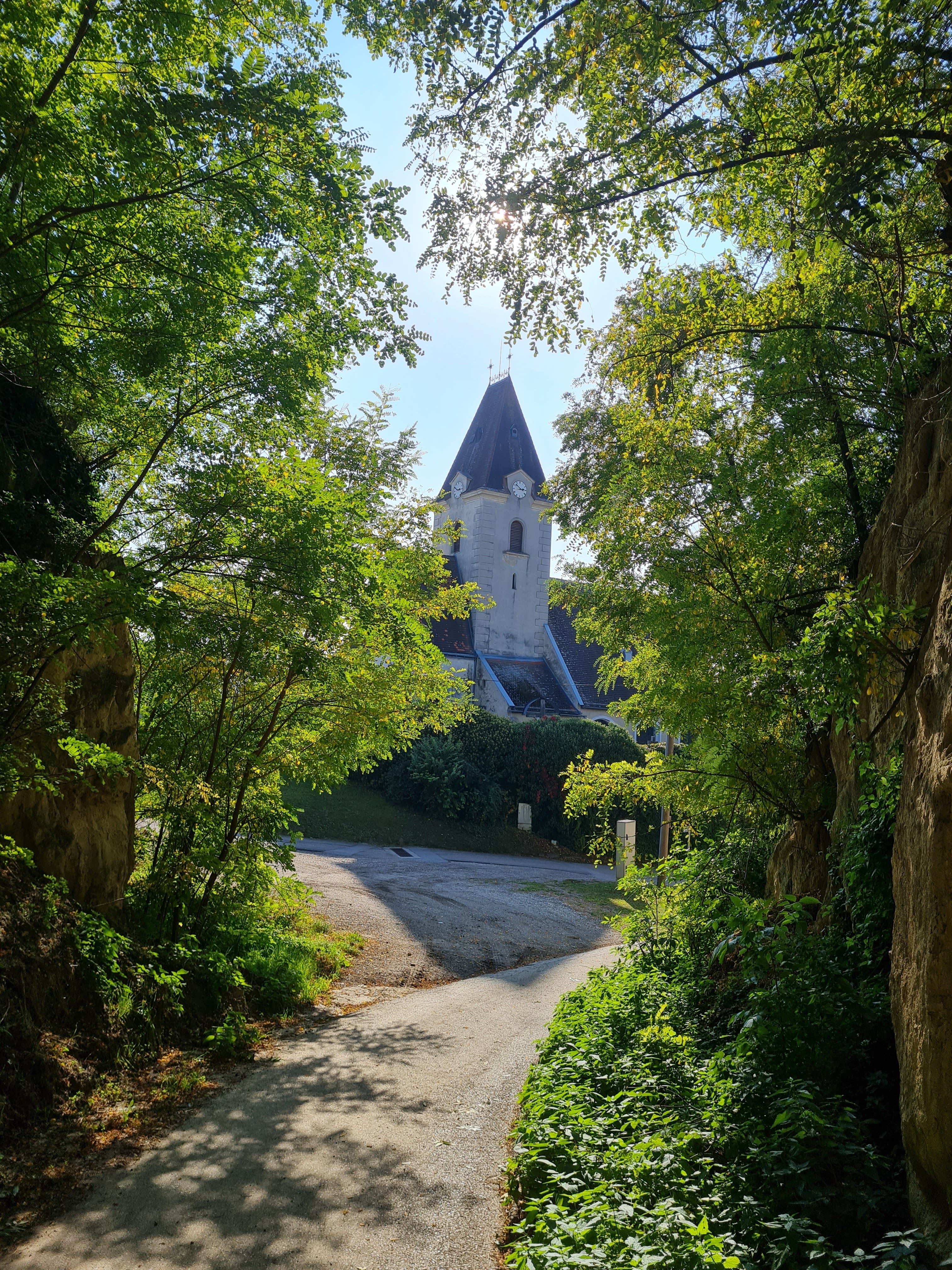 Schattiger Hohlweg, im Hintergrund eine Kirche