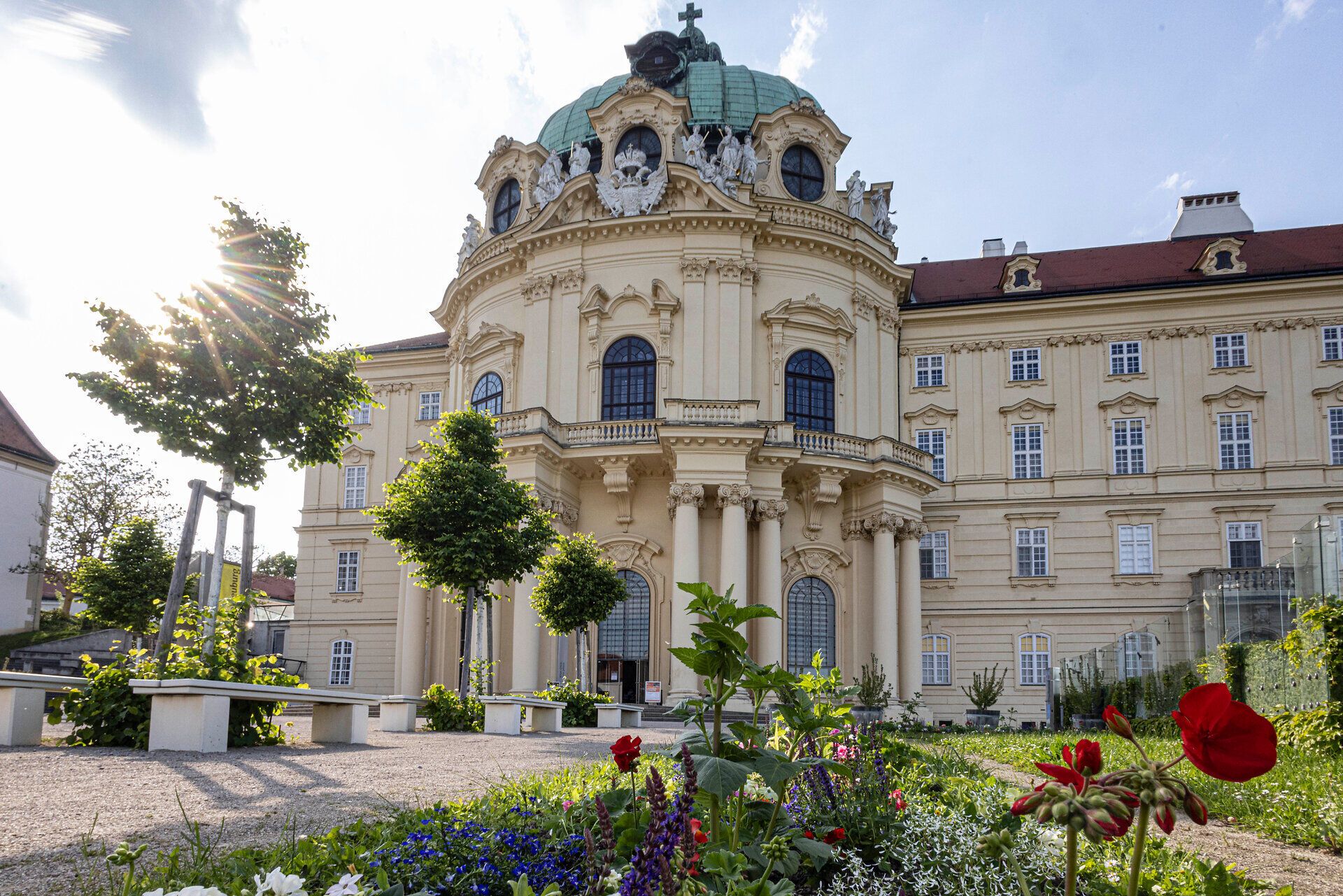 Die prächtige Architektur des Stifts Klosterneuburg erhebt sich majestätisch über die blühenden Gärten, die mit bunten Blumen und üppigem Grün geschmückt sind. Hier, wo Geschichte und Natur harmonisch verschmelzen, lädt die ruhige Atmosphäre zum Verweilen und Entspannen ein.