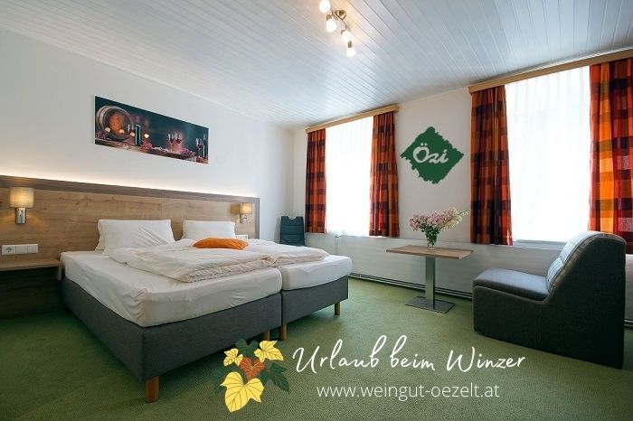Gemütliches Gästezimmer mit Doppelbett, Tisch, Stuhl und dekorativen Elementen an den Wänden.