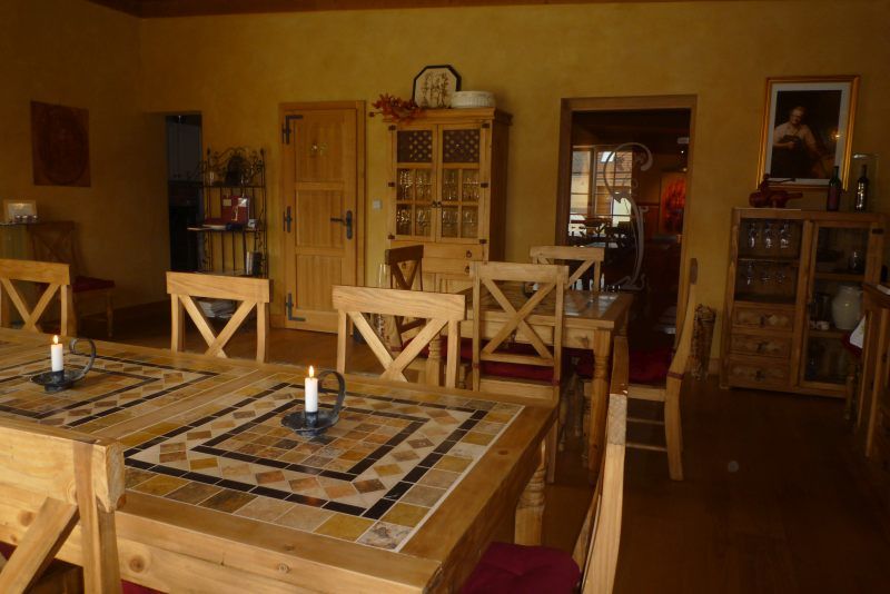 Gemütlicher Raum mit Holzmöbeln und Kerzen auf den Tischen.