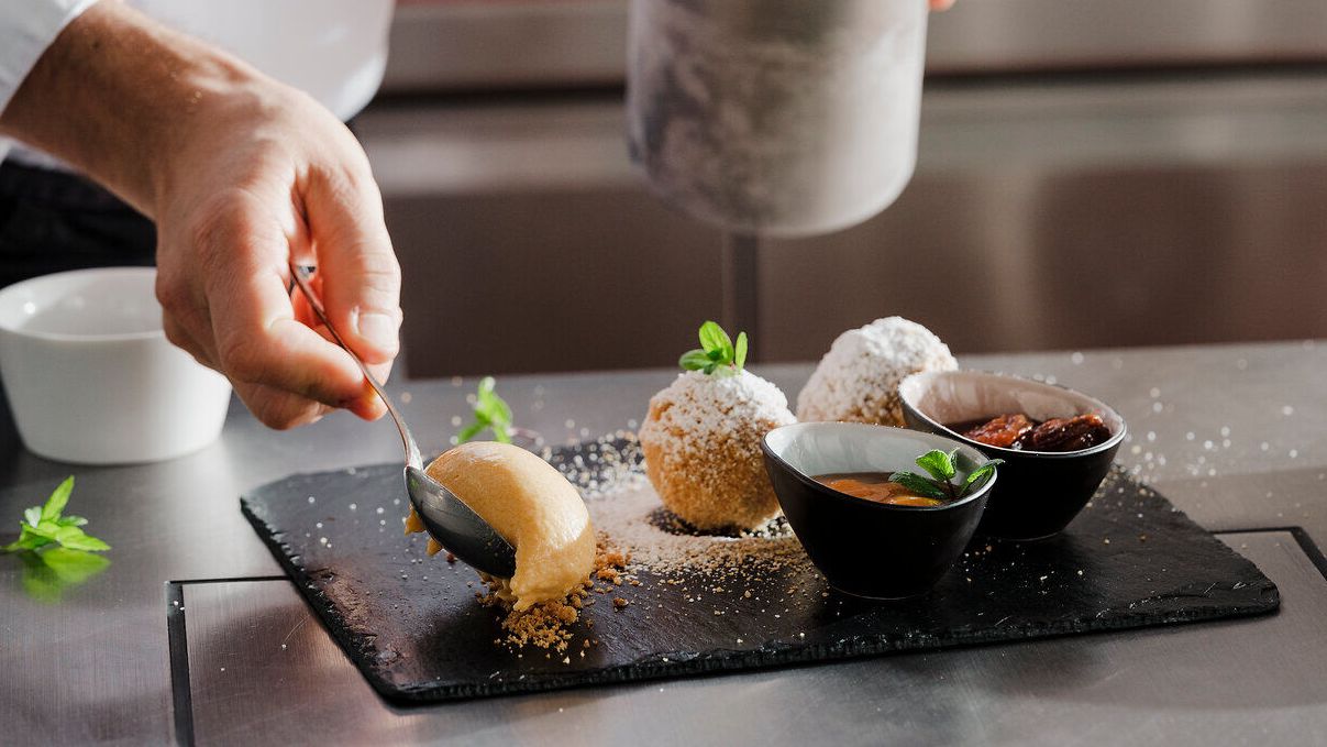 Ein talentierter Koch vollbringt Meisterwerke in der Küche, während er ein köstliches Dessert anrichtet. Die feinen Aromen und die kunstvolle Präsentation versprechen ein unvergessliches Geschmackserlebnis. Hier, wo Tradition und Genuss aufeinandertreffen, wird jeder Bissen zum Fest für die Sinne.