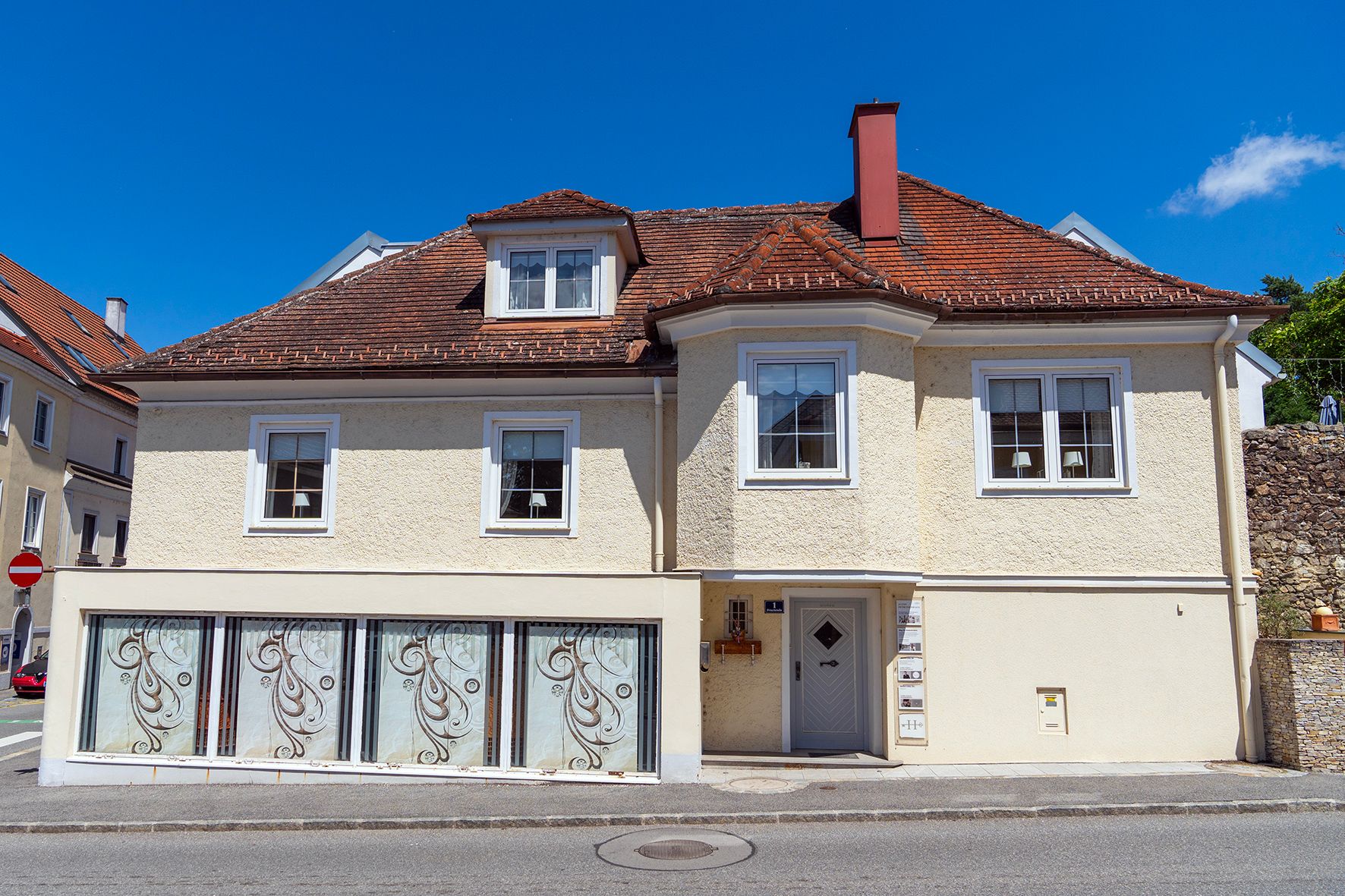 Large yellow house with a display window on the ground floor