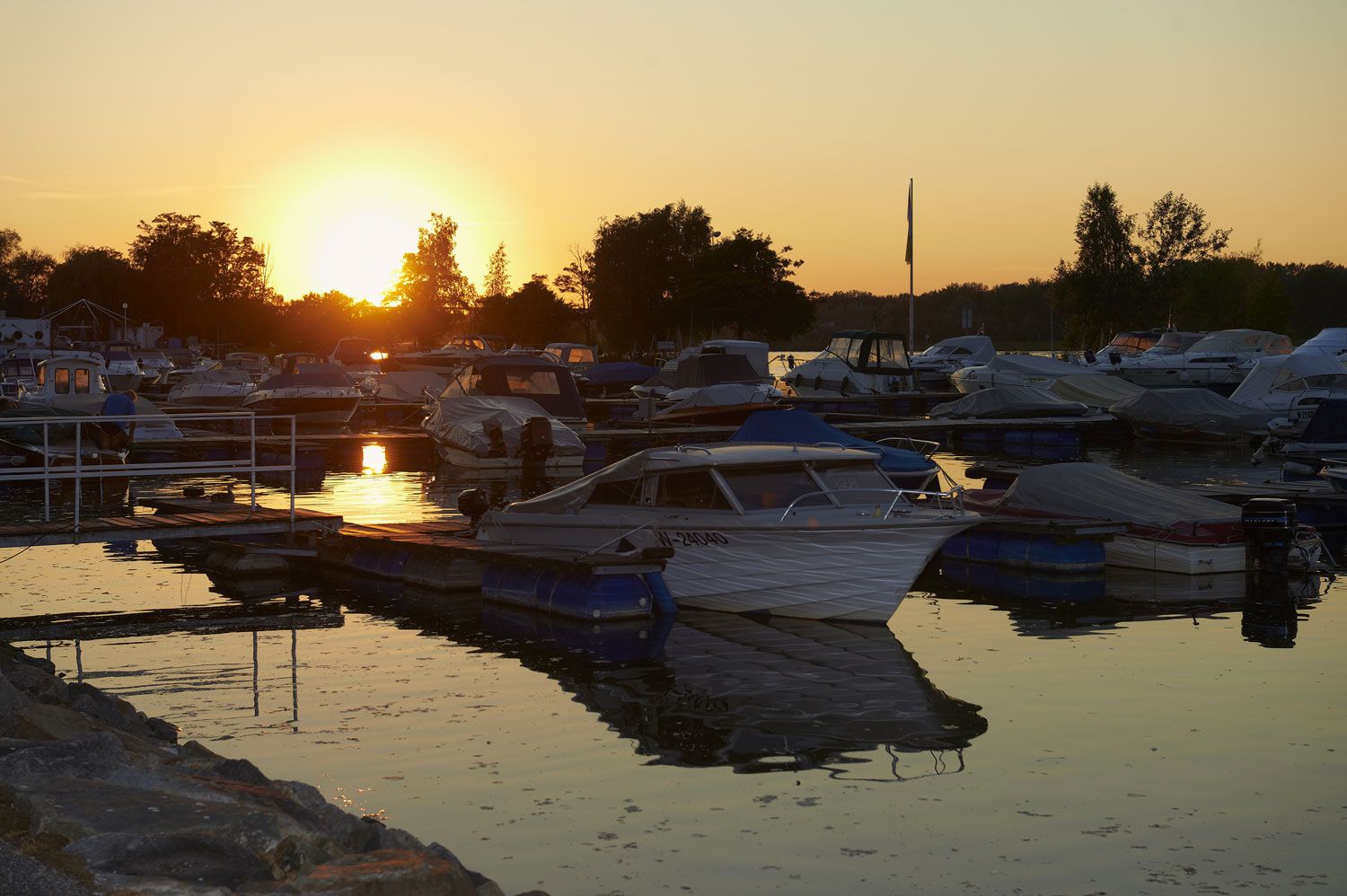 Sunset over a marina with several boats in the water.