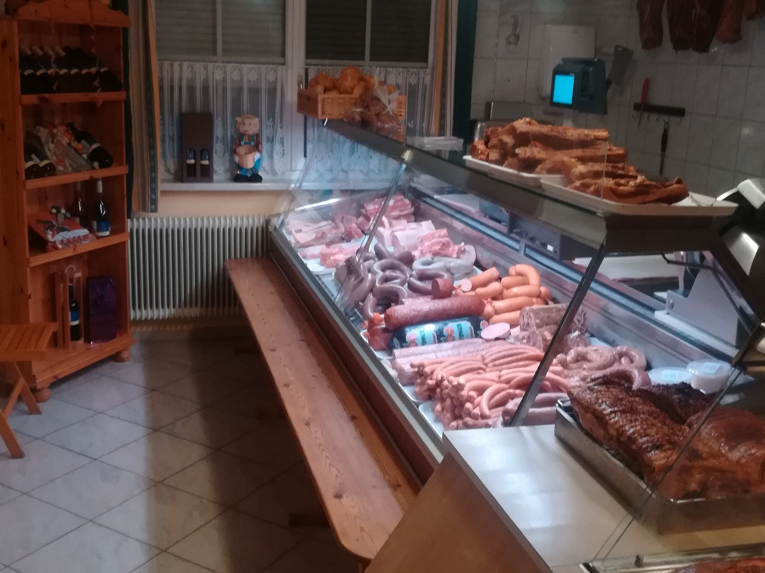 Metzgerei mit Fleisch- und Wurstwaren in einer Verkaufstheke.