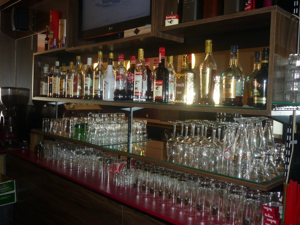 Regal mit Flaschen und Gläsern in einer Bar.
