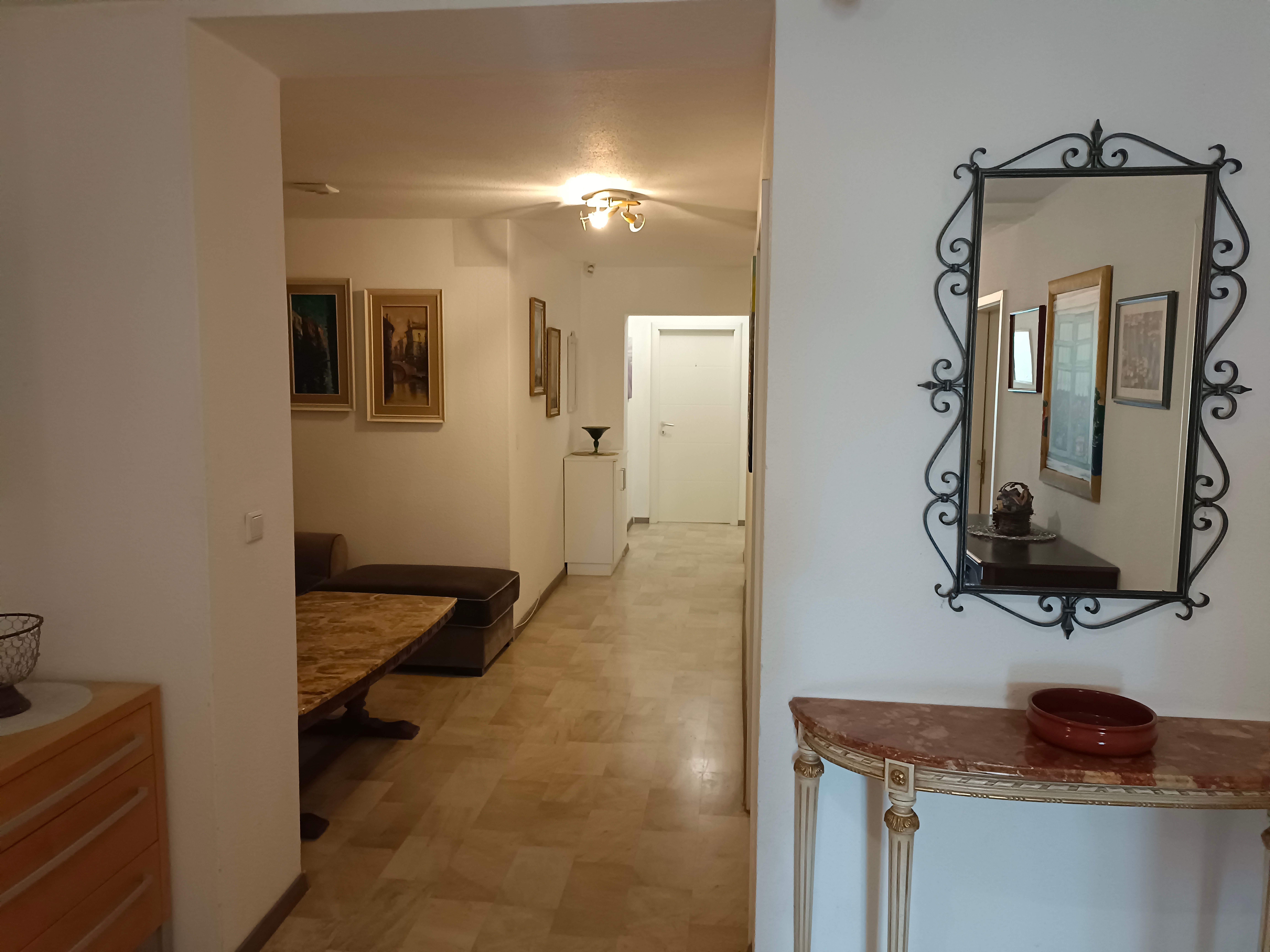 Flur mit Spiegel, Gemälden und Möbeln in einem Gasthof.