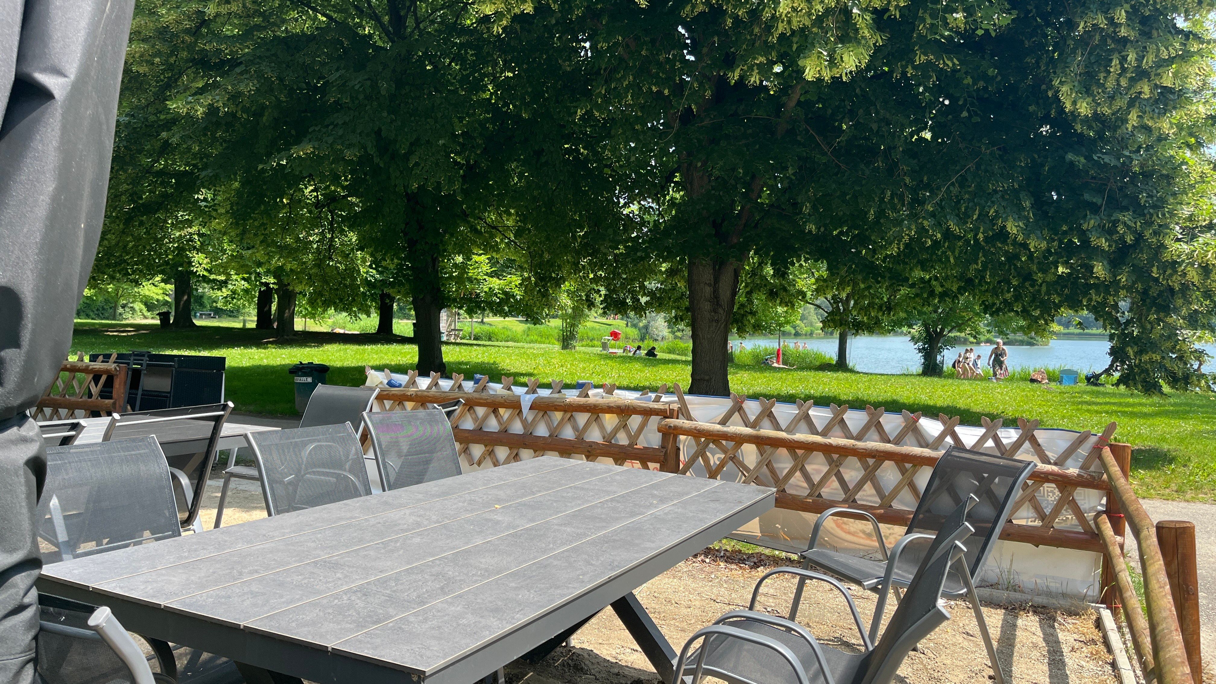 Gartentisch mit Gartenstühlen, im Hintergrund das Tullner-Aubad.