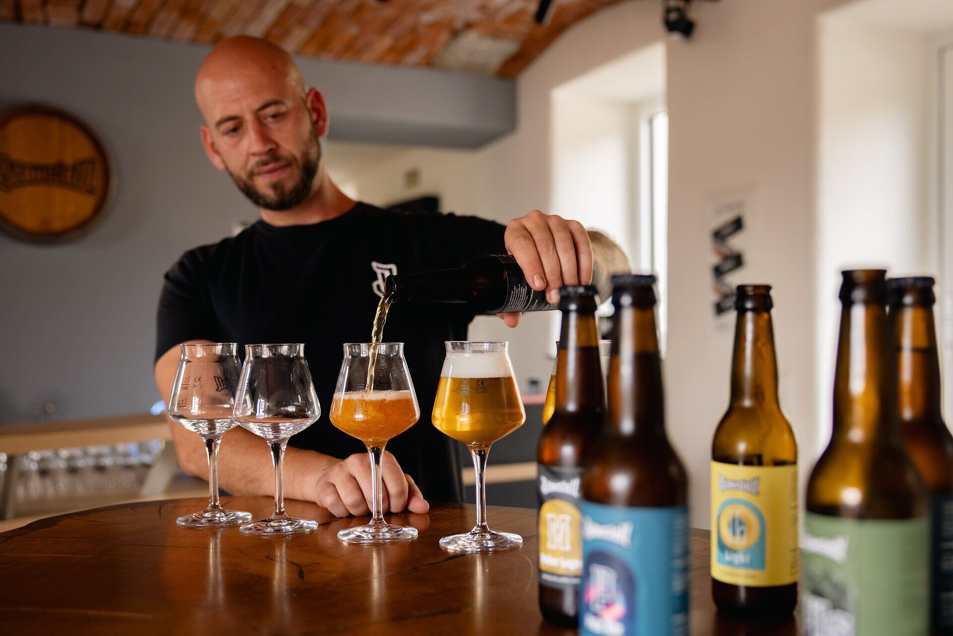 Mann schenkt Bier in Gläser ein.