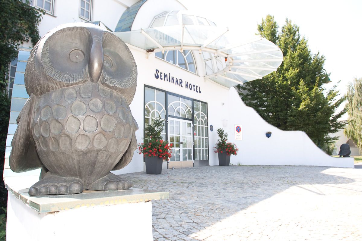 Eingang eines Seminarhotels mit Eulenskulptur.