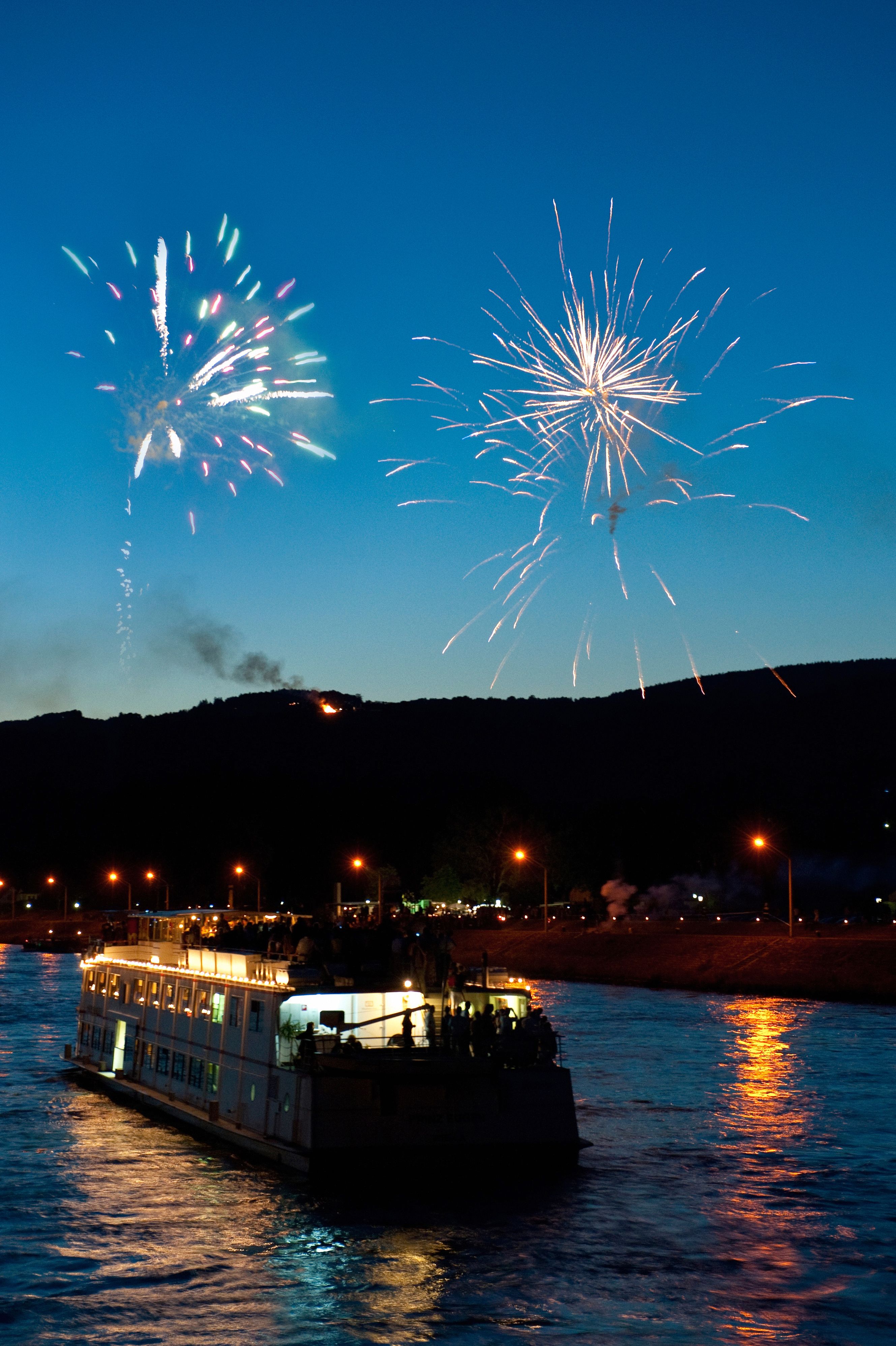 Ein beleuchtetes Schiff fährt in der Dämmerung auf der Donau
