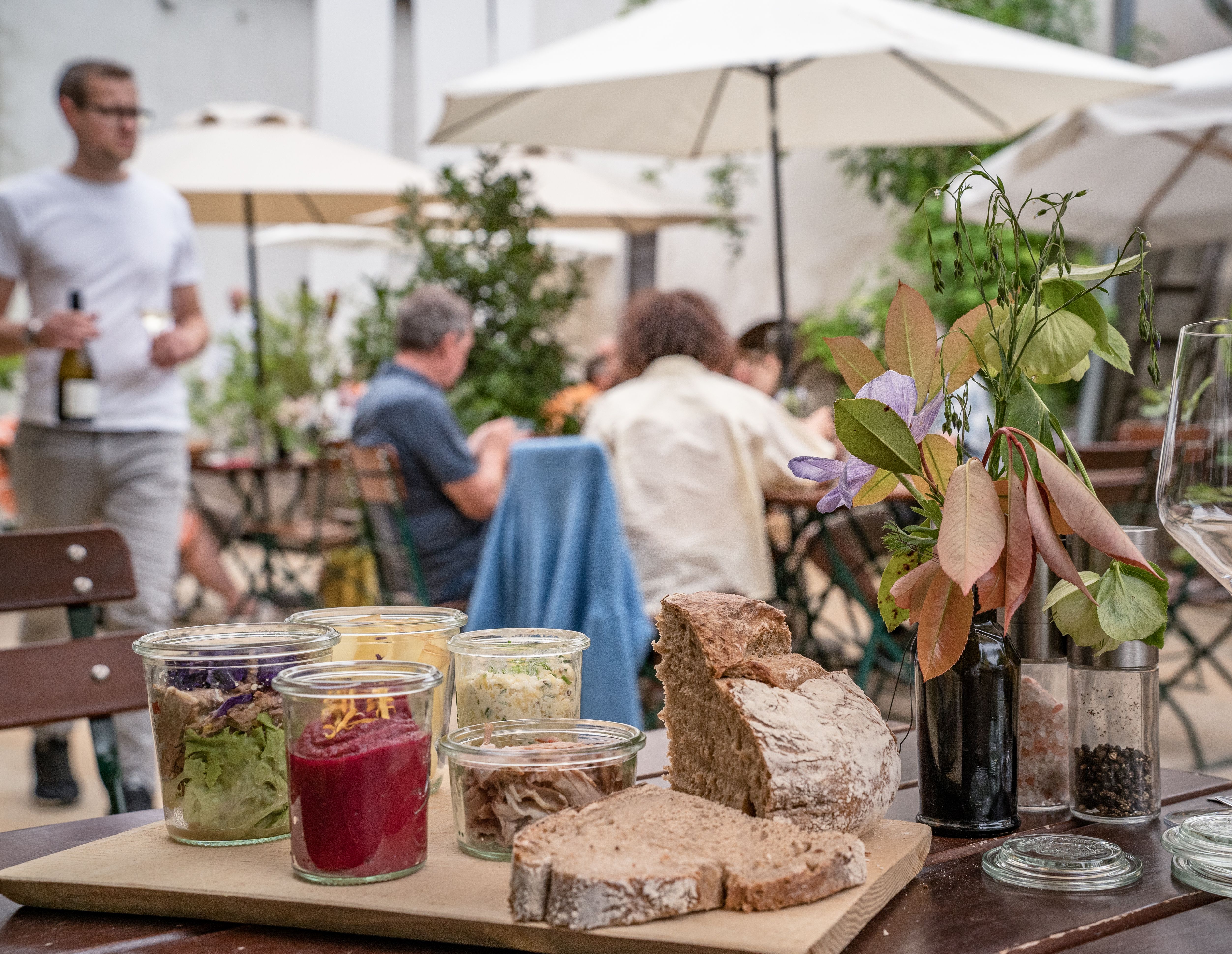 Gäste genießen regionale Spezialitäten und Wein beim Heurigen