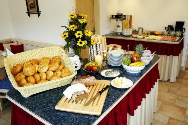 Svédasztalos reggeli zsemlével, gyümölcsökkel és virágokkal.