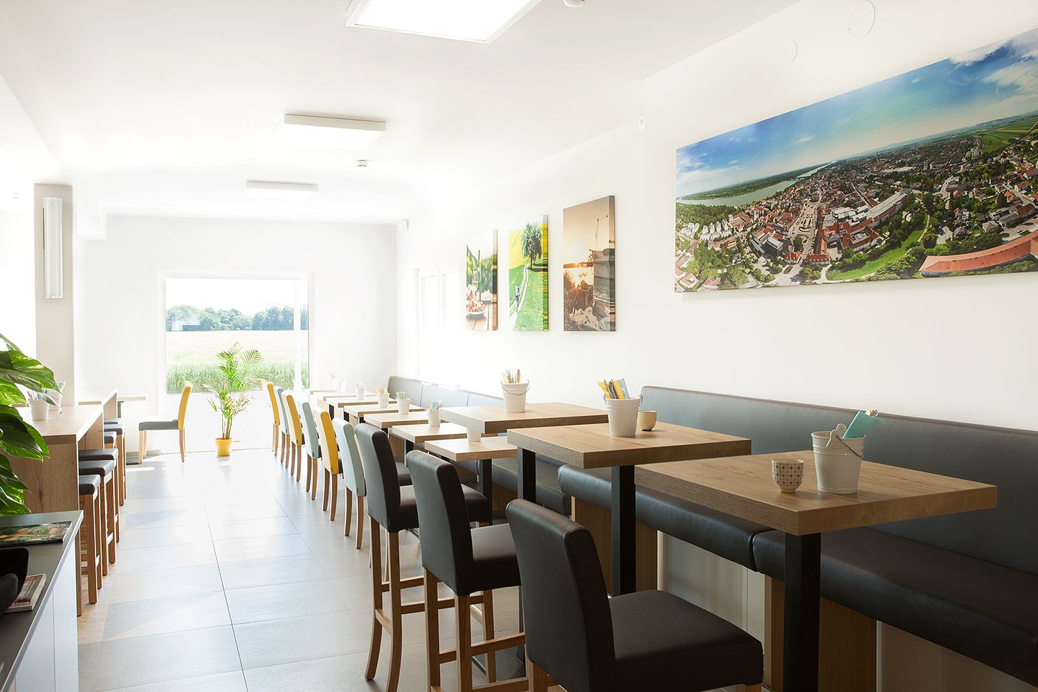 Frühstücksraum mit grau gepolsterten Sitzmöglichkeiten und Holztischen.