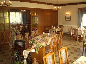 Innenansicht eines traditionellen Gasthofs mit Holzmöbeln und dekorierten Tischen.