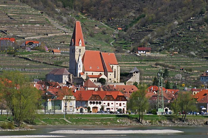 Wehrkirche in Weißenkirchen in der Wachau mit umliegenden Gebäuden und Weinbergen.