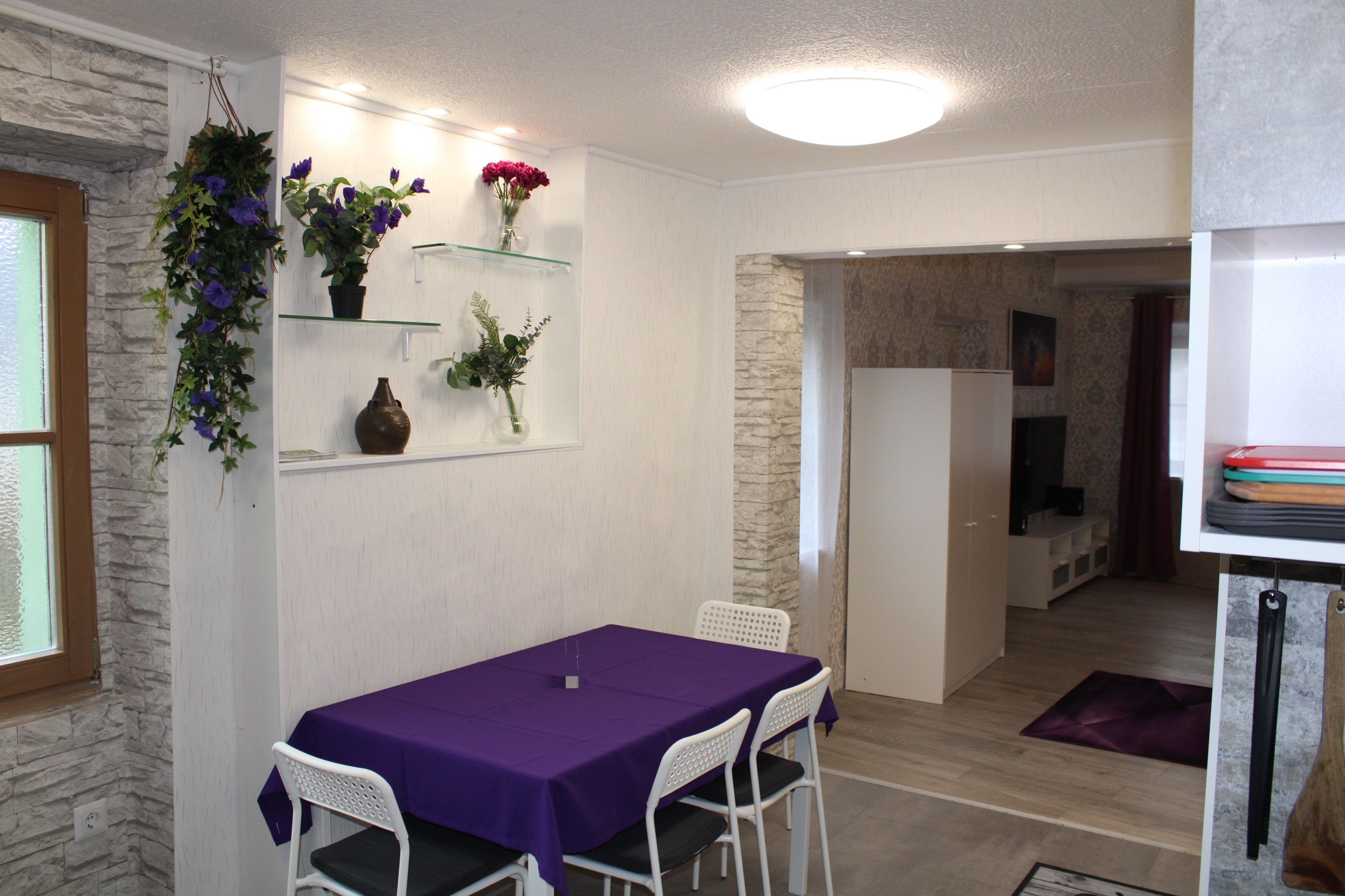 Violetter Tisch mit weißen Sesseln