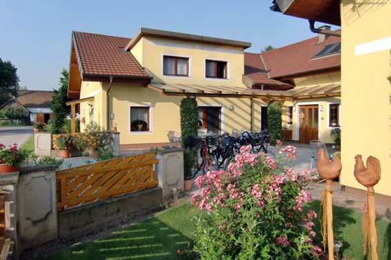 Gelbes Haus mit Garten und Fahrrädern vor der Tür.