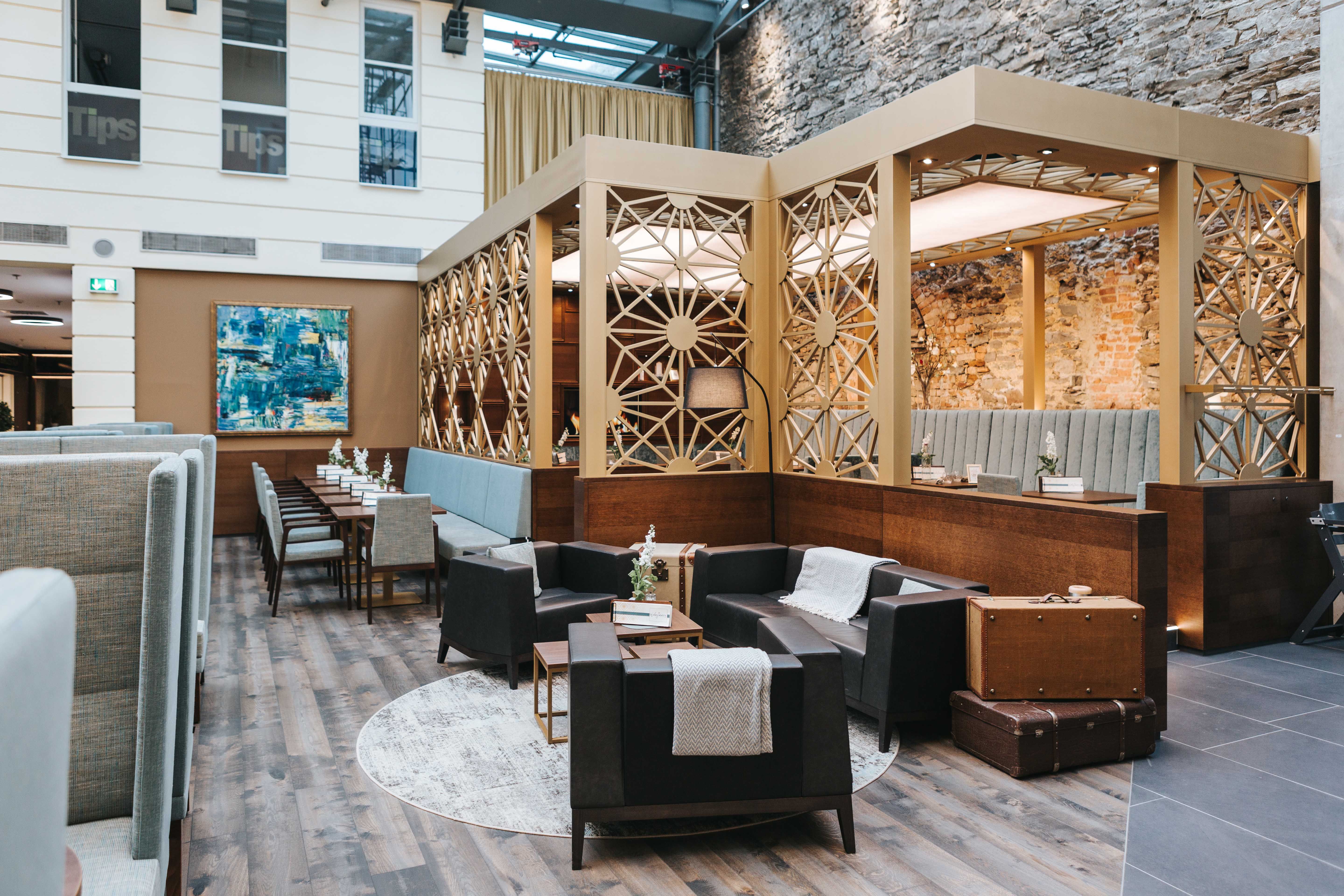 Innenansicht eines stilvollen Cafés mit modernen Möbeln und dekorativen Wänden.